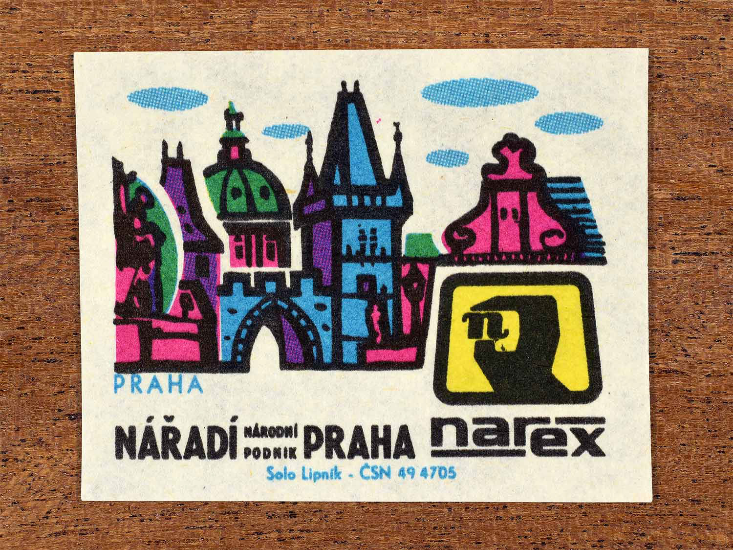Vintage 1967 Czech matchbox label showing a stylised Prague cityscape with historic towers and bridges in bright green, blue and pink. Produced by the Solo Lipník match factory to promote Prague and Narex, the national tool enterprise in Czechoslovakia.