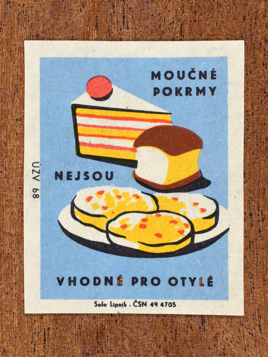 Vintage c. 1968 Czech matchbox label showing cakes flour-base treats on a blue background. Produced by the Solo Lipník match factory to discourage flour-based foods for overweight people.