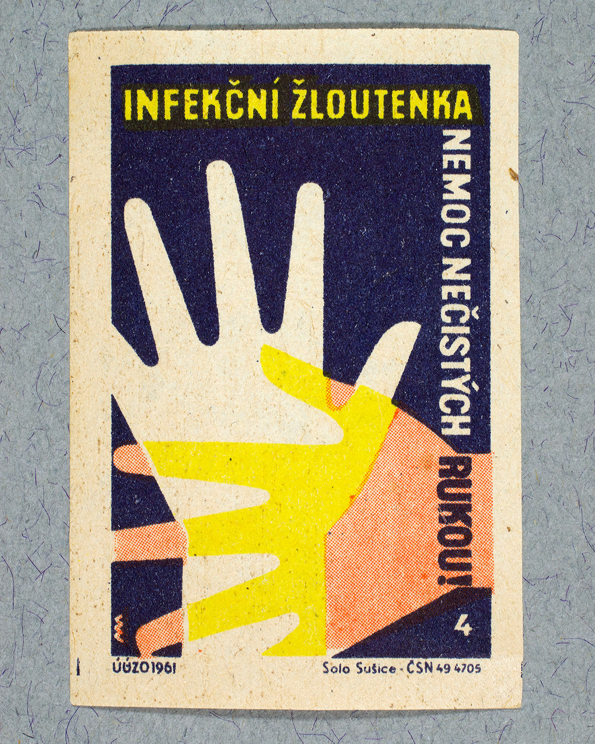 1961 Czech matchbox label by Solo Sušice showing two overlapping hands in yellow and white. Used as a public service message promoting personal hygiene and warning of infection spread through unwashed hands.