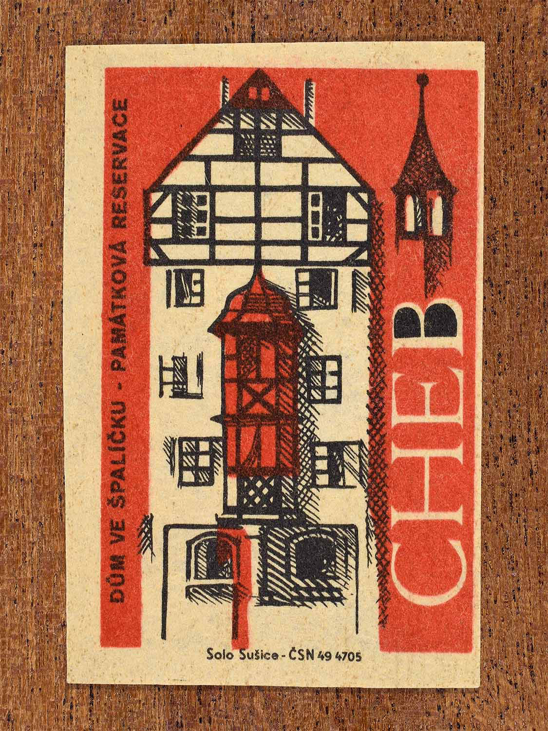 Vintage 1964 Czech matchbox label showing the House at Špalíček in Cheb, on red background. Produced by the Solo Sušice match factory to promote awareness of protected historic monuments.