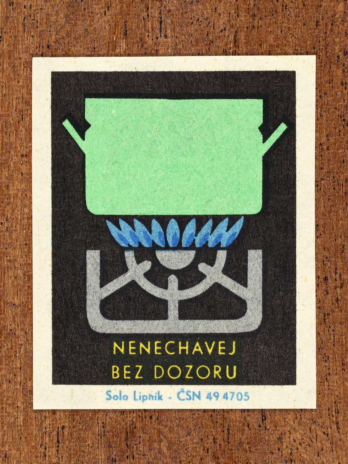 Vintage c. 1966 Czech matchbox label showing a pot boiling on a lit gas stove in green, blue, yellow and black colours. Produced by the Solo Lipník match factory to promote safe, modern, and responsible domestic propane–butane gas use.