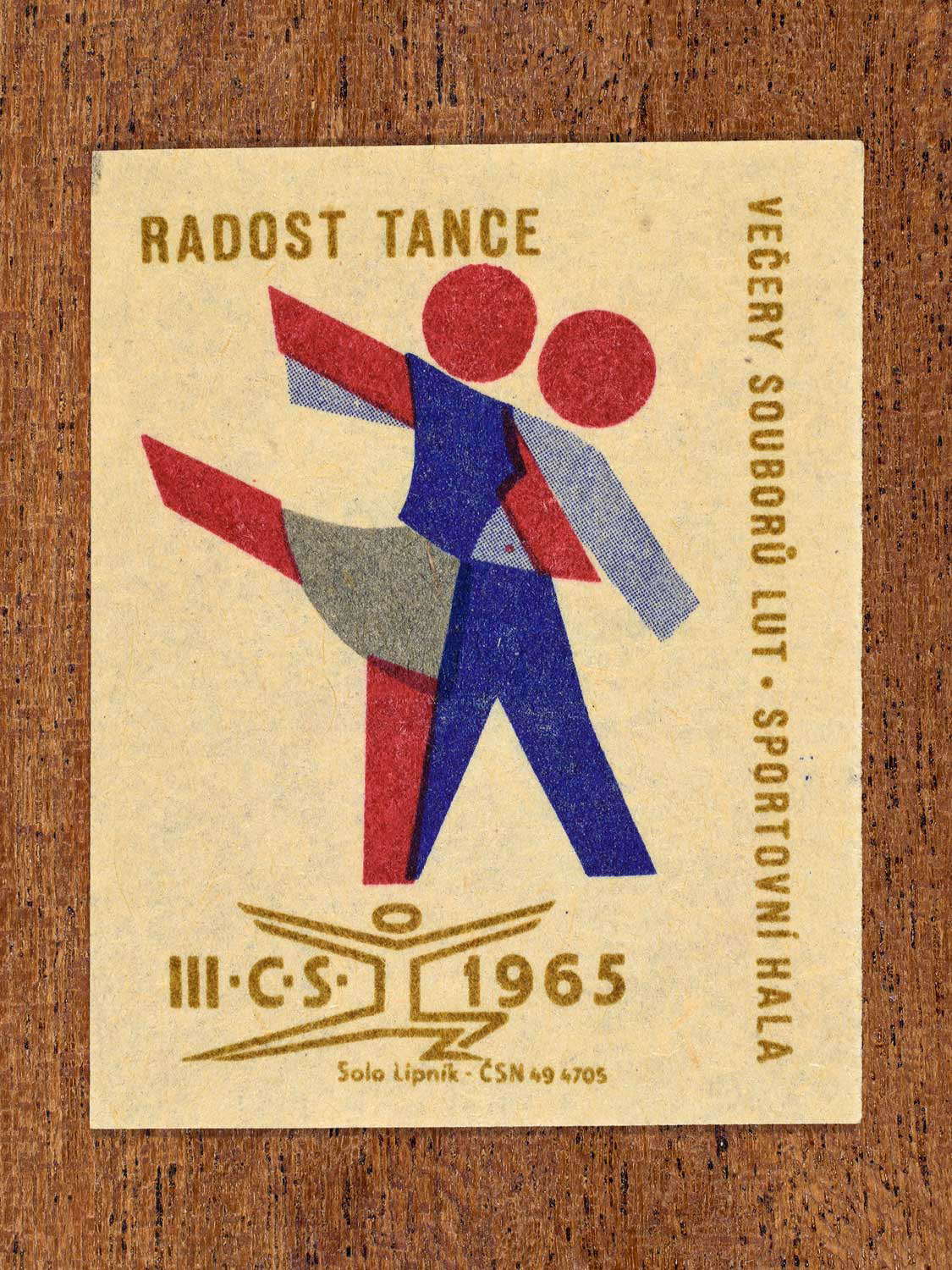 Vintage 1965 Czechoslovak matchbox label showing two stylised folk dancers in blue, red and gold colours. Produced by the Solo Lipník match factory to promote joyful social dance.
