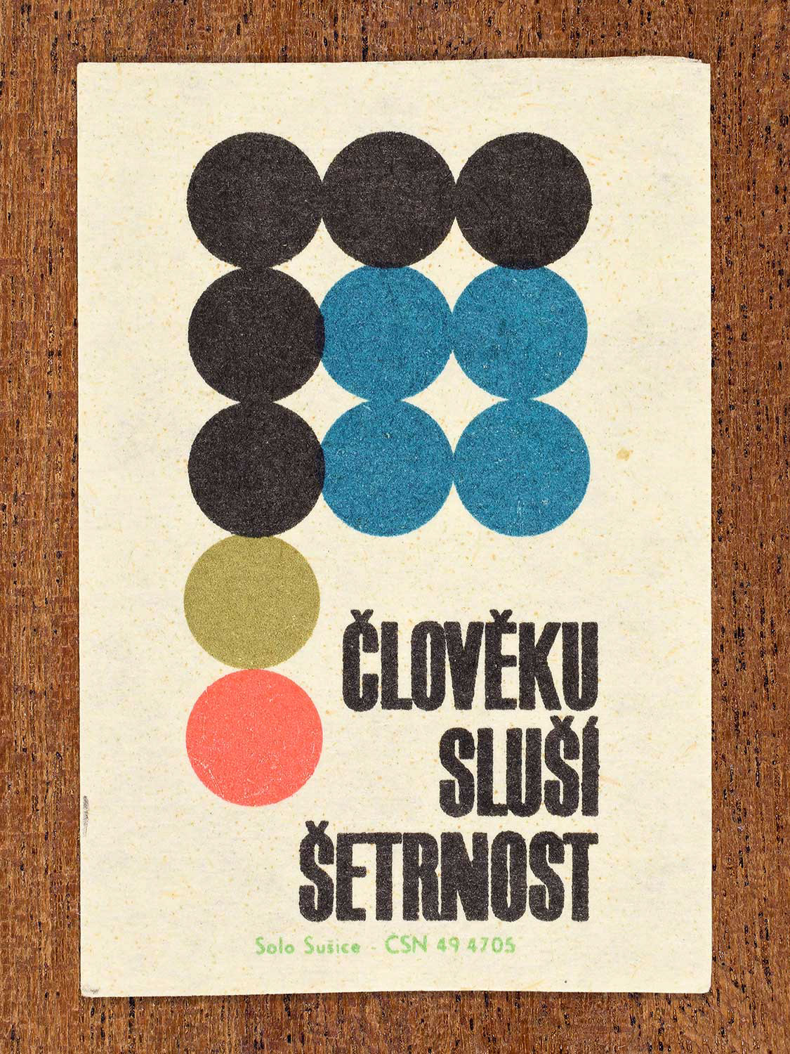 Vintage Czech matchbox label showing a repeating grid of coloured circles arranged in a geometric pattern. Produced by the Solo Sušice match factory in 1966 to promote frugality and economical personal behaviour.