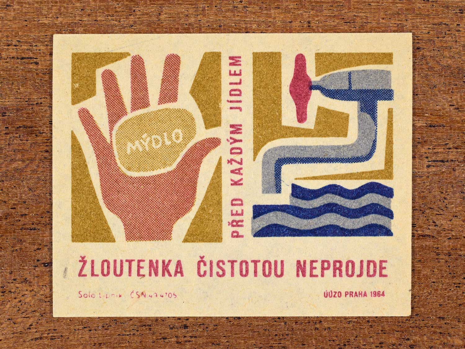 Vintage 1964 Czech matchbox label showing a stylised hand, soap, a tap, and running water. Produced by the Solo Lipník match factory to promote handwashing in the prevention of infectious jaundice (hepatitis).
