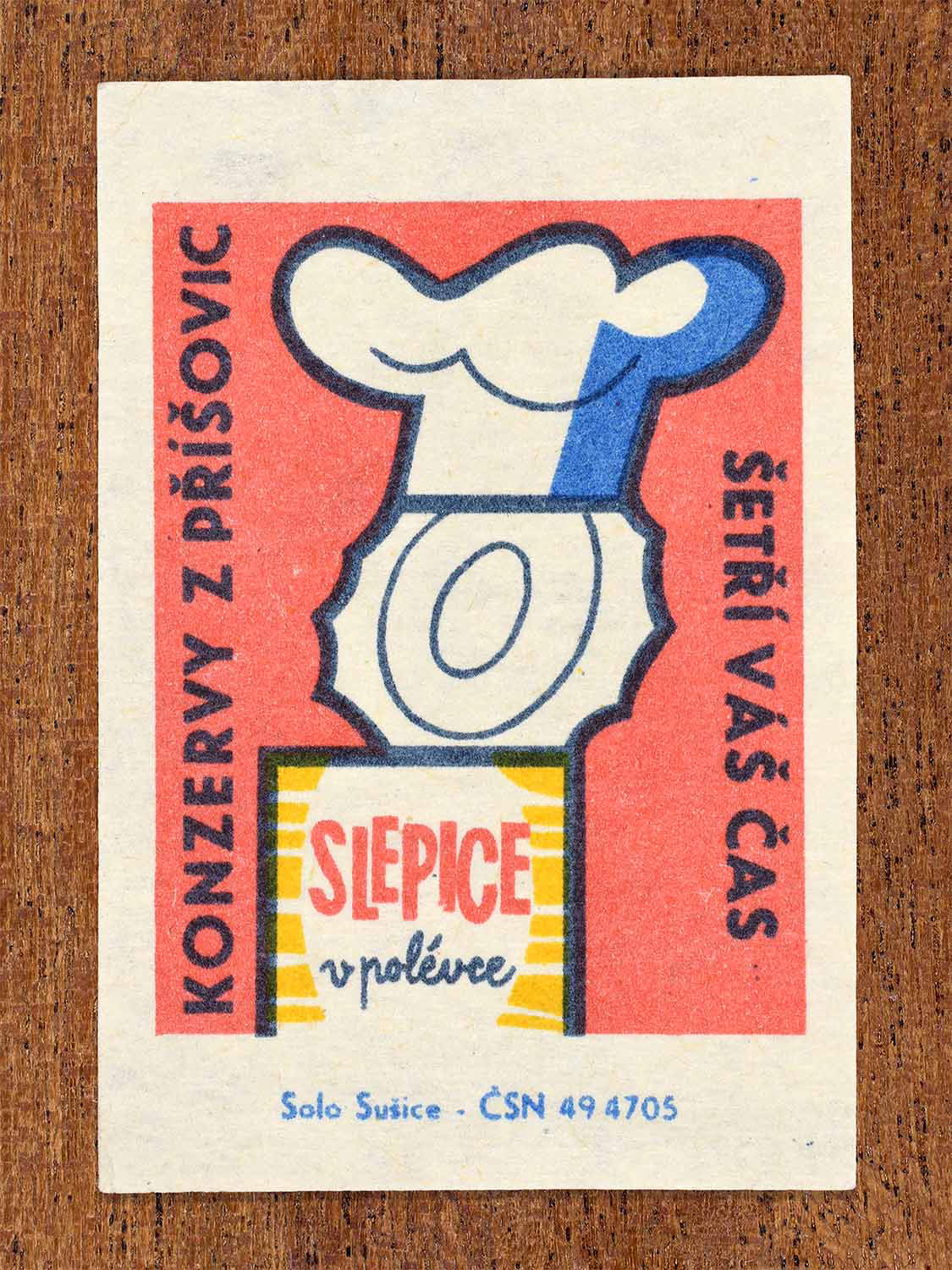 Vintage c. 1966 Czech matchbox label showing an open can wearing a chef hat in red, blue and yellow colours. Produced by the Solo Lipník match factory to promote time-saving canned poultry meals from Příšovice.