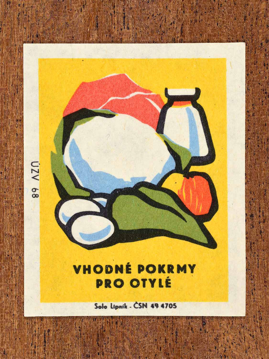 Vintage c. 1968 Czech matchbox label showing vegetables, bread and milk on a yellow background. Produced by the Solo Lipník match factory to promote suitable foods for overweight people.