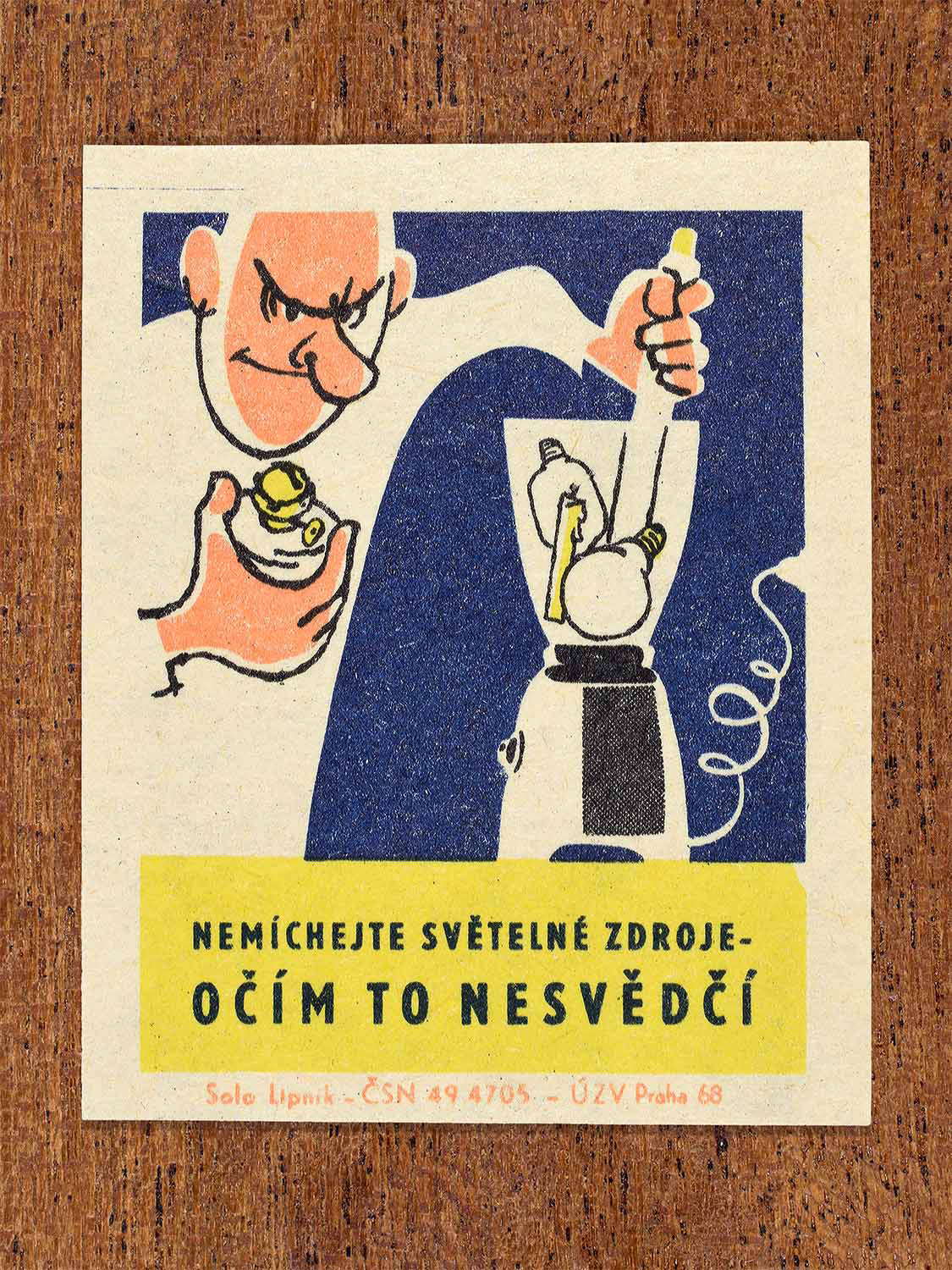 Vintage 1968 Czech matchbox label featuring a cartoon person filling an electric blender with light bulbs, on blue background. Produced by Solo Lipník match factory to promote proper lighting and maintenance for eye health and safe work practices.