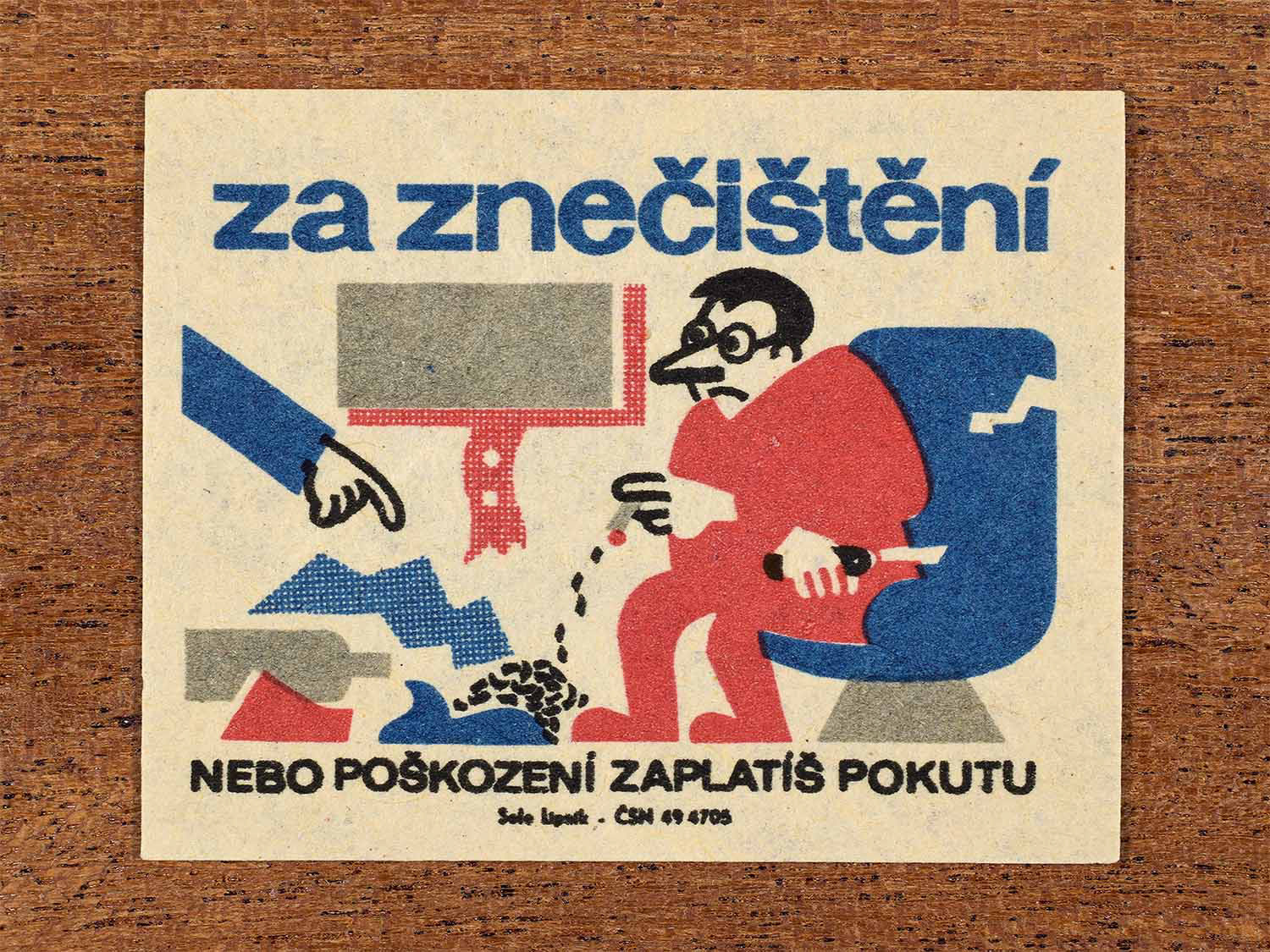 Vintage c. 1964 Czech matchbox label showing a passenger damaging train property, illustrated in red, blue and black. Produced by the Solo Lipník match factory to warn that pollution or damage results in fines.