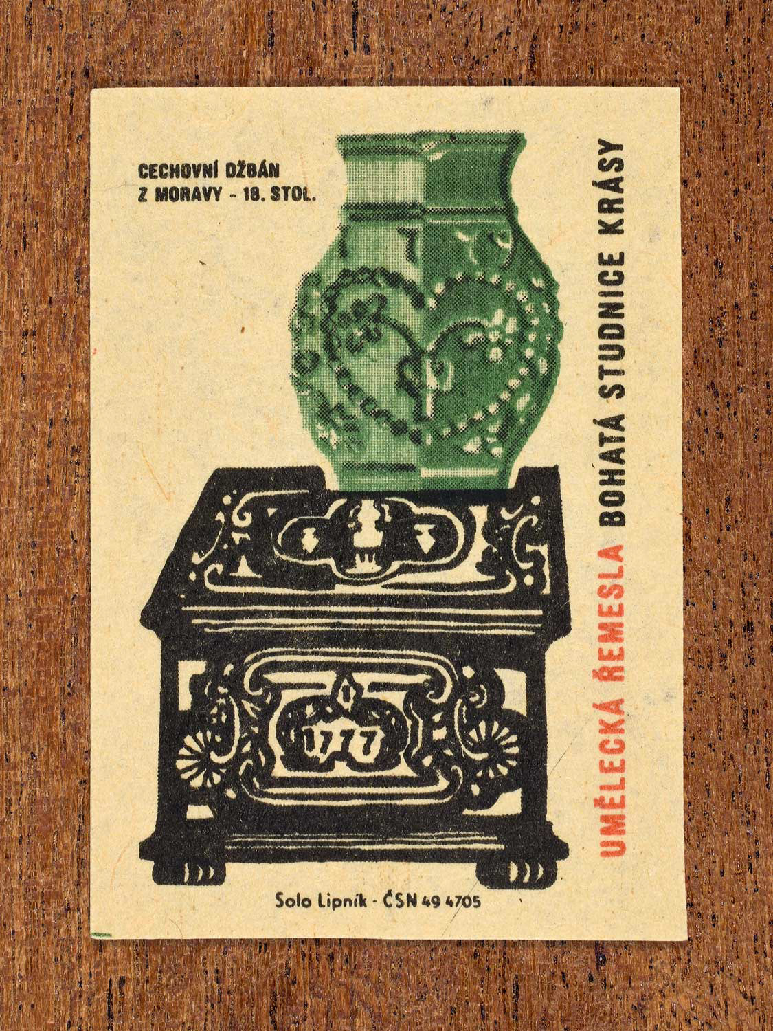 Vintage 1964 Czech matchbox label showing an 18th-century Moravian guild ceramic jug displayed on a decorated stove. Produced by the Solo Lipník match factory to celebrate traditional artistic crafts and folk heritage.