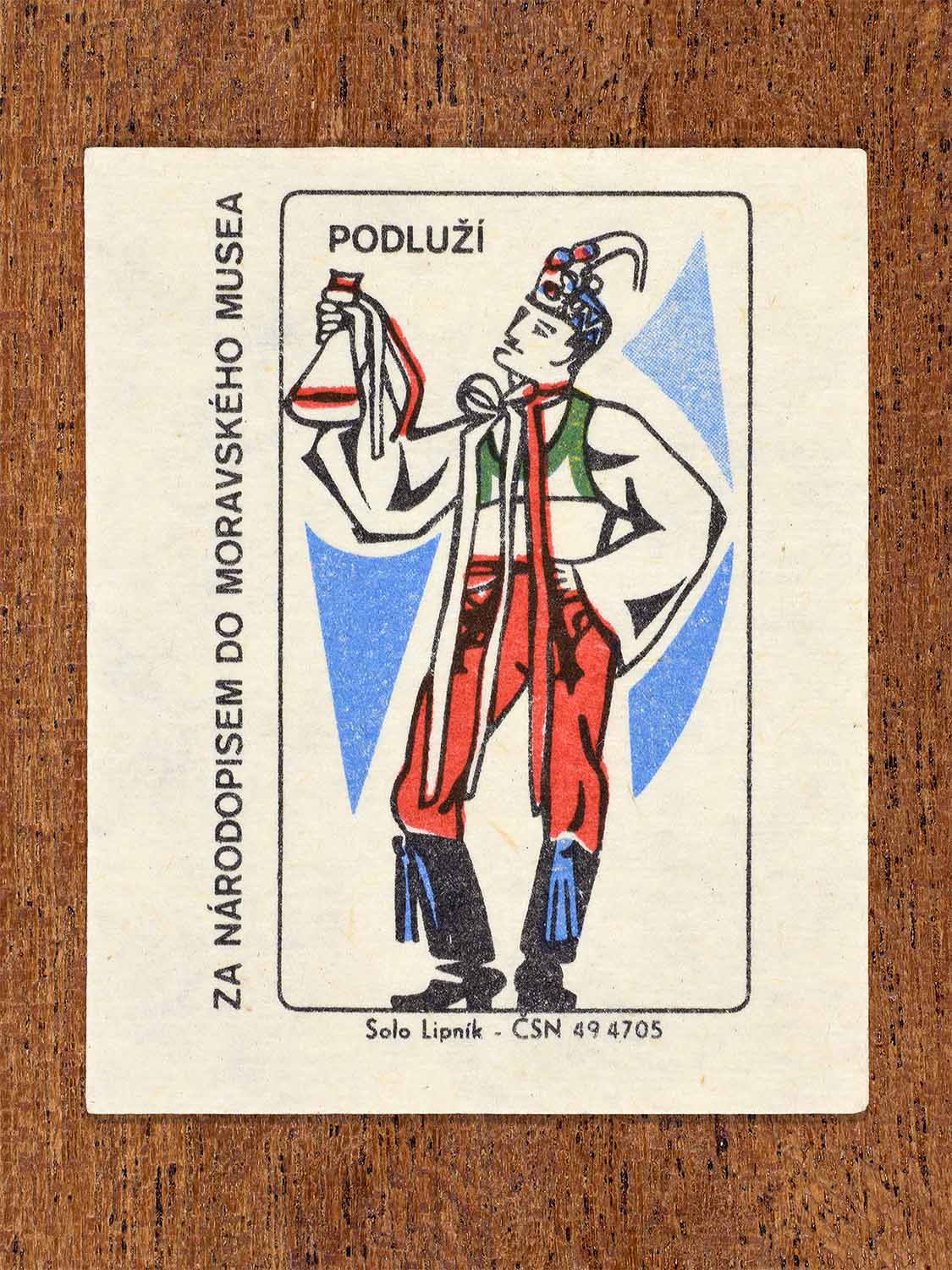 Vintage c. 1968 Czech matchbox label showing a male folk costume from the Podluží wine region holding a bottle. Produced by the Solo Lipník match factory to promote Moravian ethnography via the Moravian Museum.