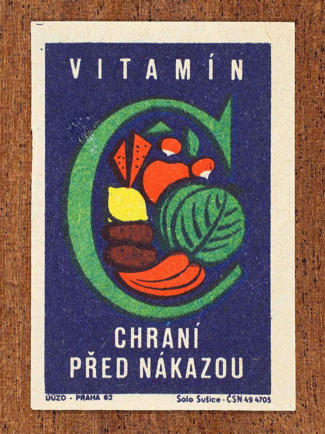 Vintage 1962 Czech matchbox label by Solo Sušice featuring a large green C filled with healthy fruits and vegetables. Part of the 'Protect Health' series celebrating vitamin C as a shield against illness.