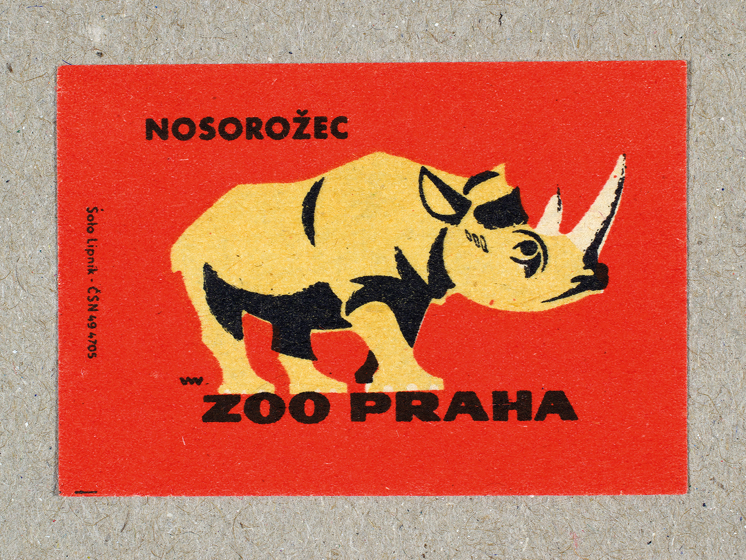 Vintage 1963 Czech matchbox label by Solo Lipník featuring a rhinoceros on a red background. Part of the 'Zoo Praha' series advertising Prague Zoo in Czechoslovakia.