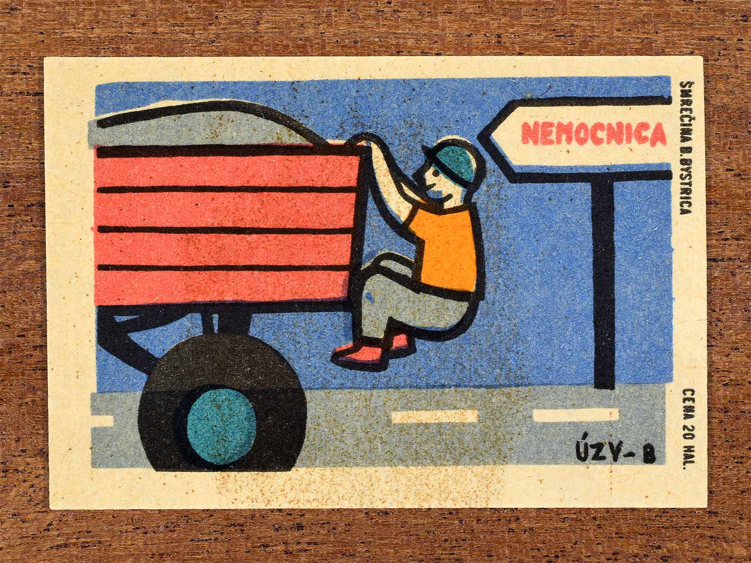 Vintage 1967 Czech matchbox label showing a careless worker hanging off the back of a moving vehicle, in blue and red colours. Produced by the Smrečná match factory, Banská Bystrica, to warn against unsafe workplace behaviour.