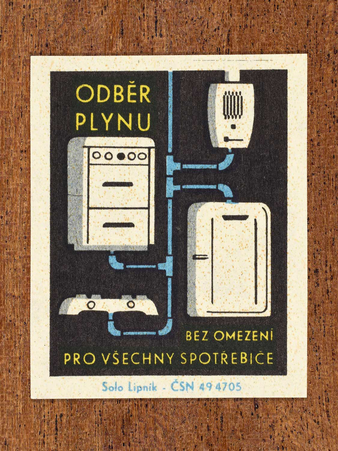Vintage c. 1966 Czech matchbox label showing four appliances connected by pipes in blue, yellow and black colours. Produced by the Solo Lipník match factory to promote safe, modern, and responsible domestic propane–butane gas use.
