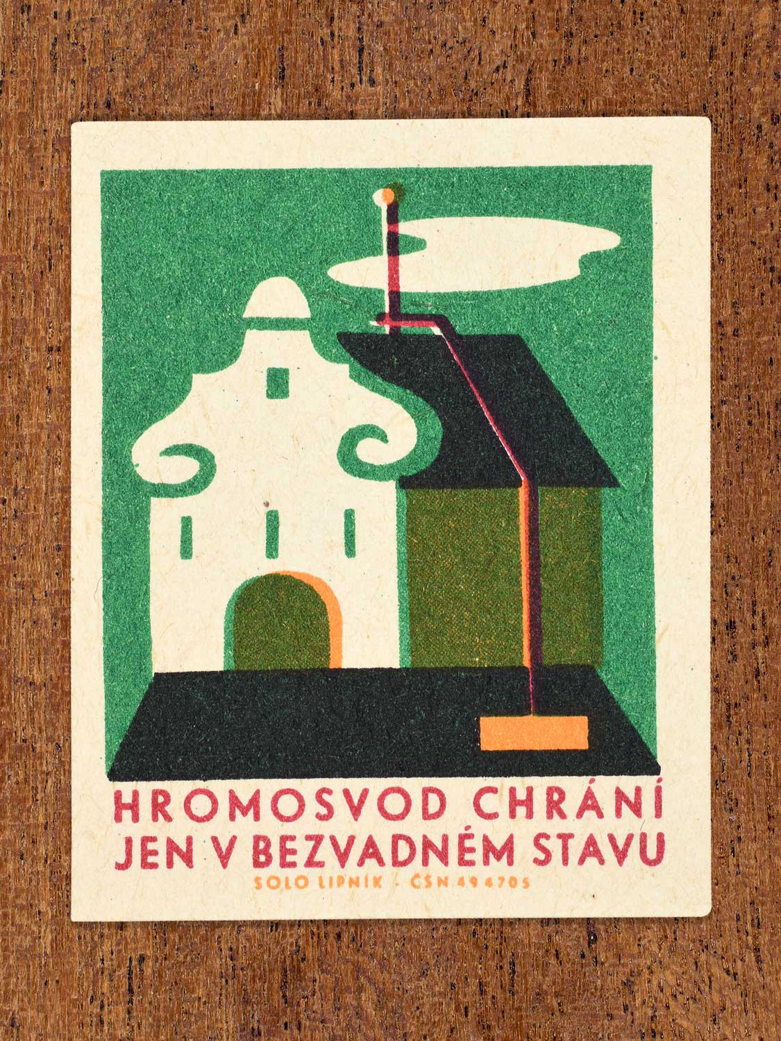 Vintage 1966 Czech matchbox label featuring a building with a lighting rod on the roof, on green background. Produced by Solo Lipník match factory to promote the importance of fire safety precautions.
