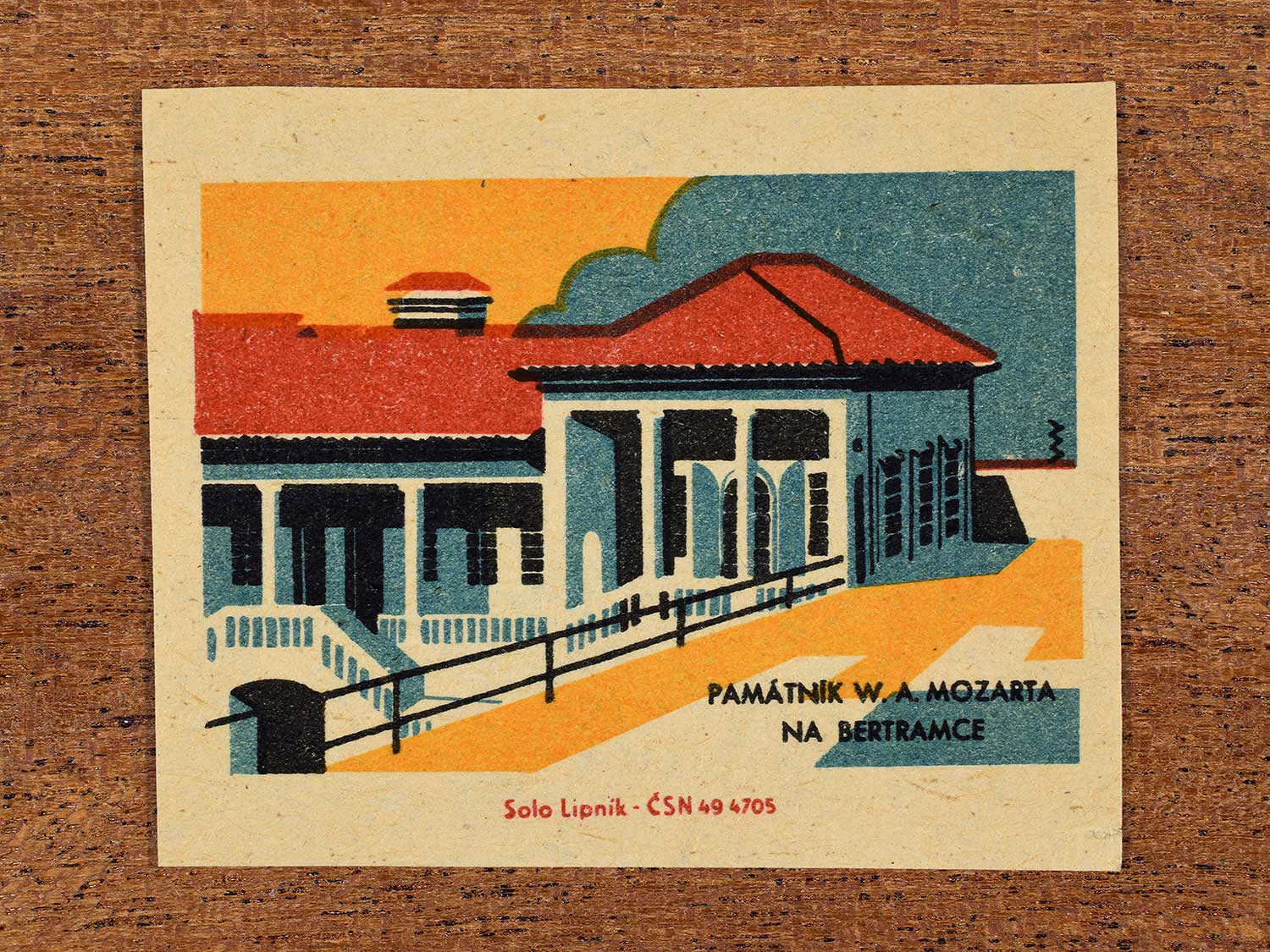 Vintage 1964 Czechoslovakia matchbox label showing the Památník W. A. Mozarta na Bertramce (Museum of W. A. Mozart at Bertramka) in yellow, red and teal colours. Produced by the Solo Lipník match factory to promote domestic historical heritage and municipal institutions across the state.