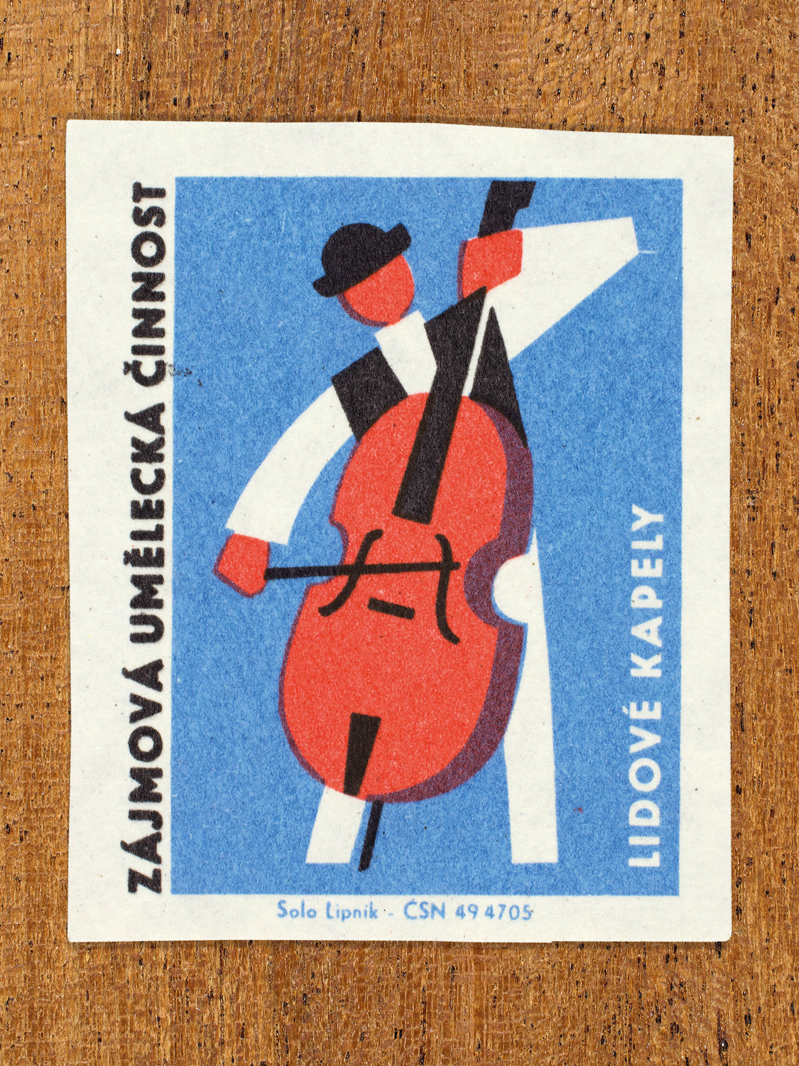 Vintage 1969 Czech matchbox label showing a stylised musician playing a large double bass, in blue, red and black colours. Produced by the Solo Lipník match factory to promote state-organised art groups in Czechoslovakia.
