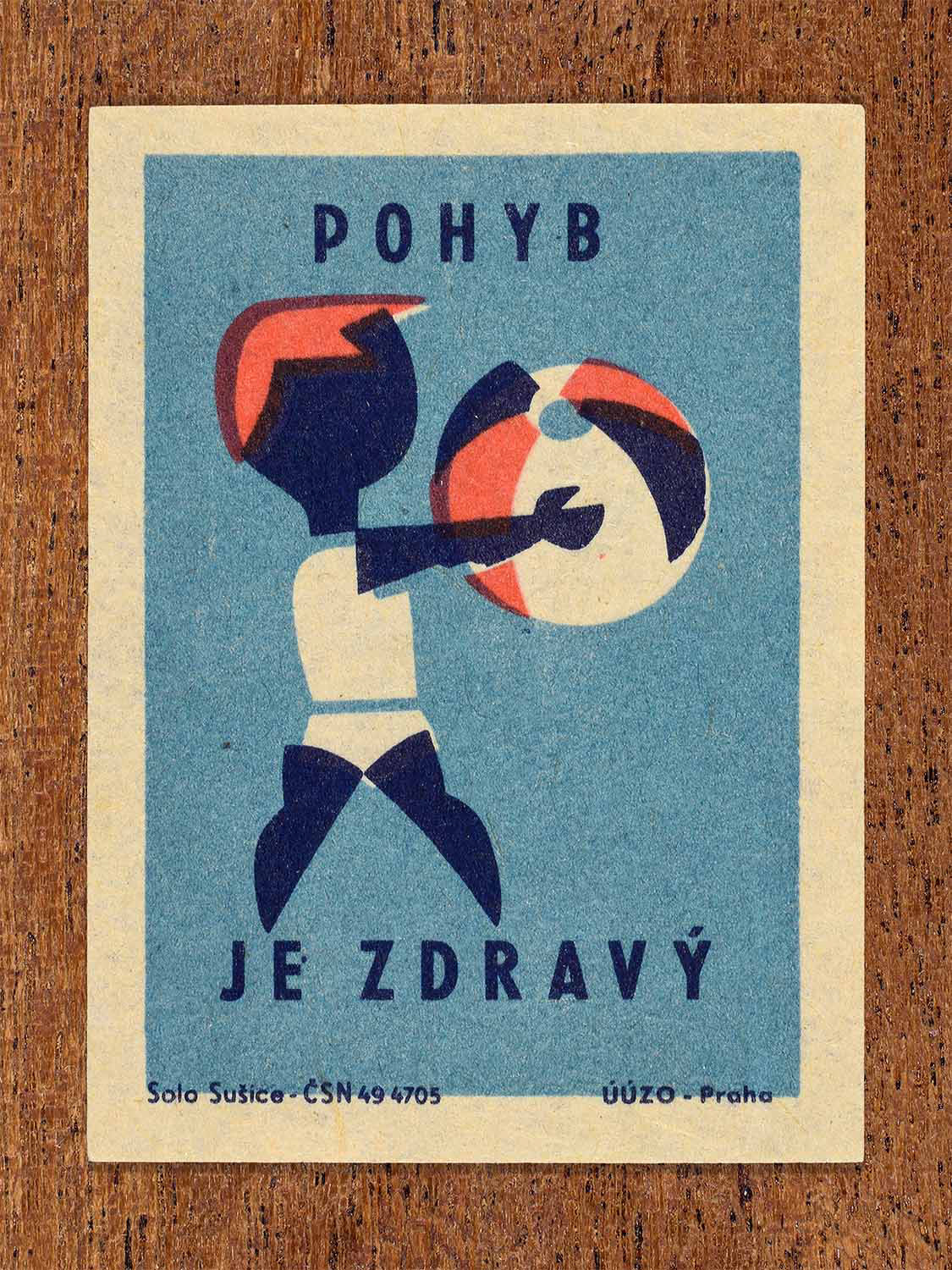 Vintage c. 1964 Czech matchbox label showing a stylised figure throwing a beachball in blue and red colours. Produced by the Solo Sušice match factory to promote physical movement as part of a healthy lifestyle.