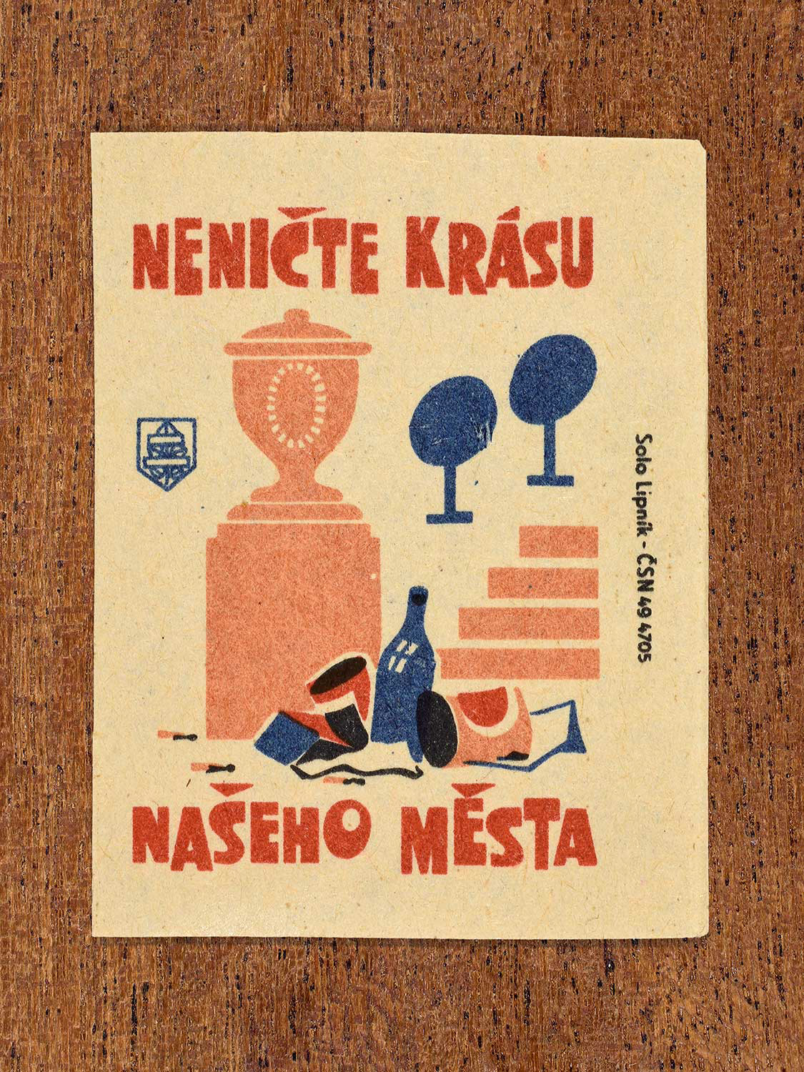 Vintage 1964 Czech matchbox label showing an urban monument surrounded by litter, in blue, red and black colours. Produced by the Solo Lipník match factory to promote respect for the visual beauty of the city.