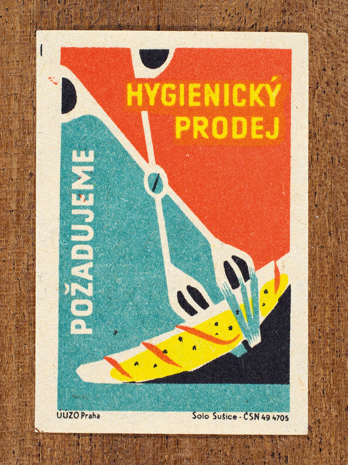 Vintage 1962 Czech matchbox label by Solo Sušice featuring metal tongs lifting sliced food. Part of the 'Food Handling' series calling for sanitary handling of groceries in food stores.