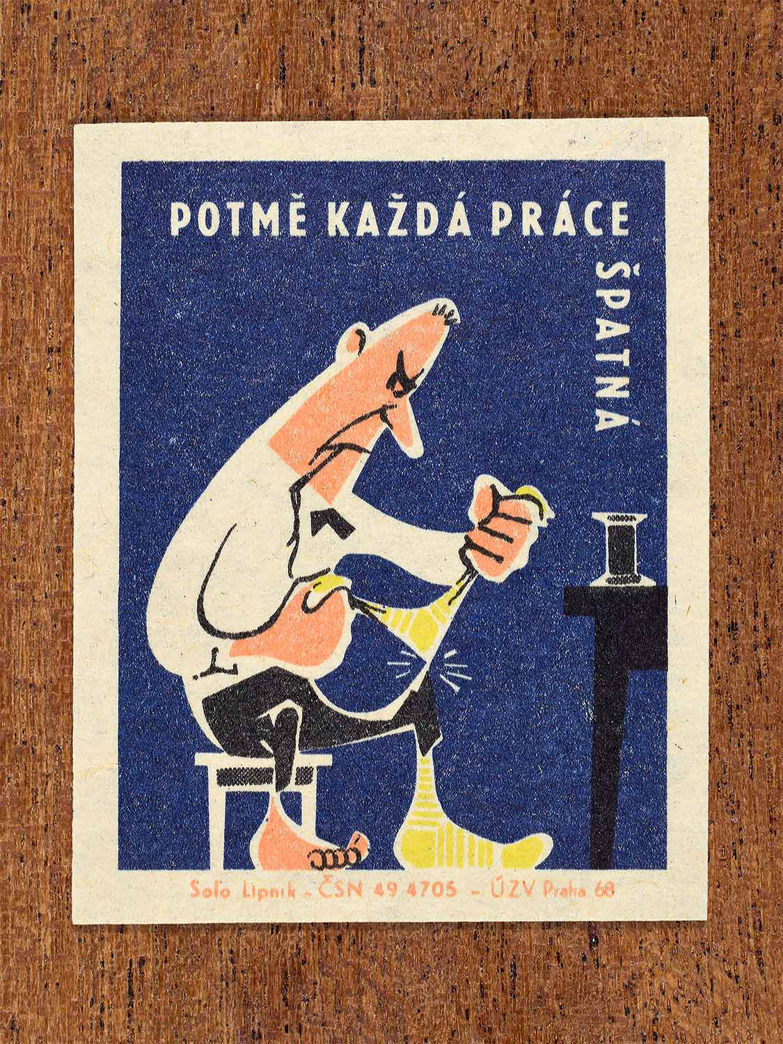 Vintage 1968 Czech matchbox label featuring a cartoon person struggling with a yellow sock, on blue background. Produced by Solo Lipník match factory to promote proper lighting and maintenance for eye health and safe work practices.