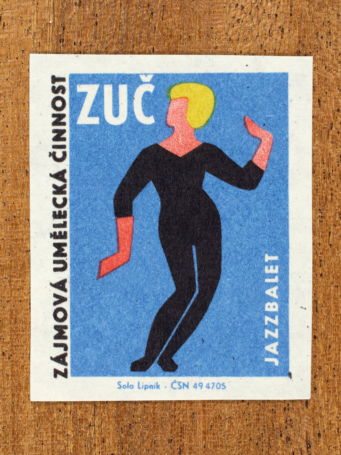 Vintage 1969 Czech matchbox label showing a stylised dancer in a fitted outfit striking a pose, in blue, red, yellow and black colours. Produced by the Solo Lipník match factory to promote state-organised art groups in Czechoslovakia.