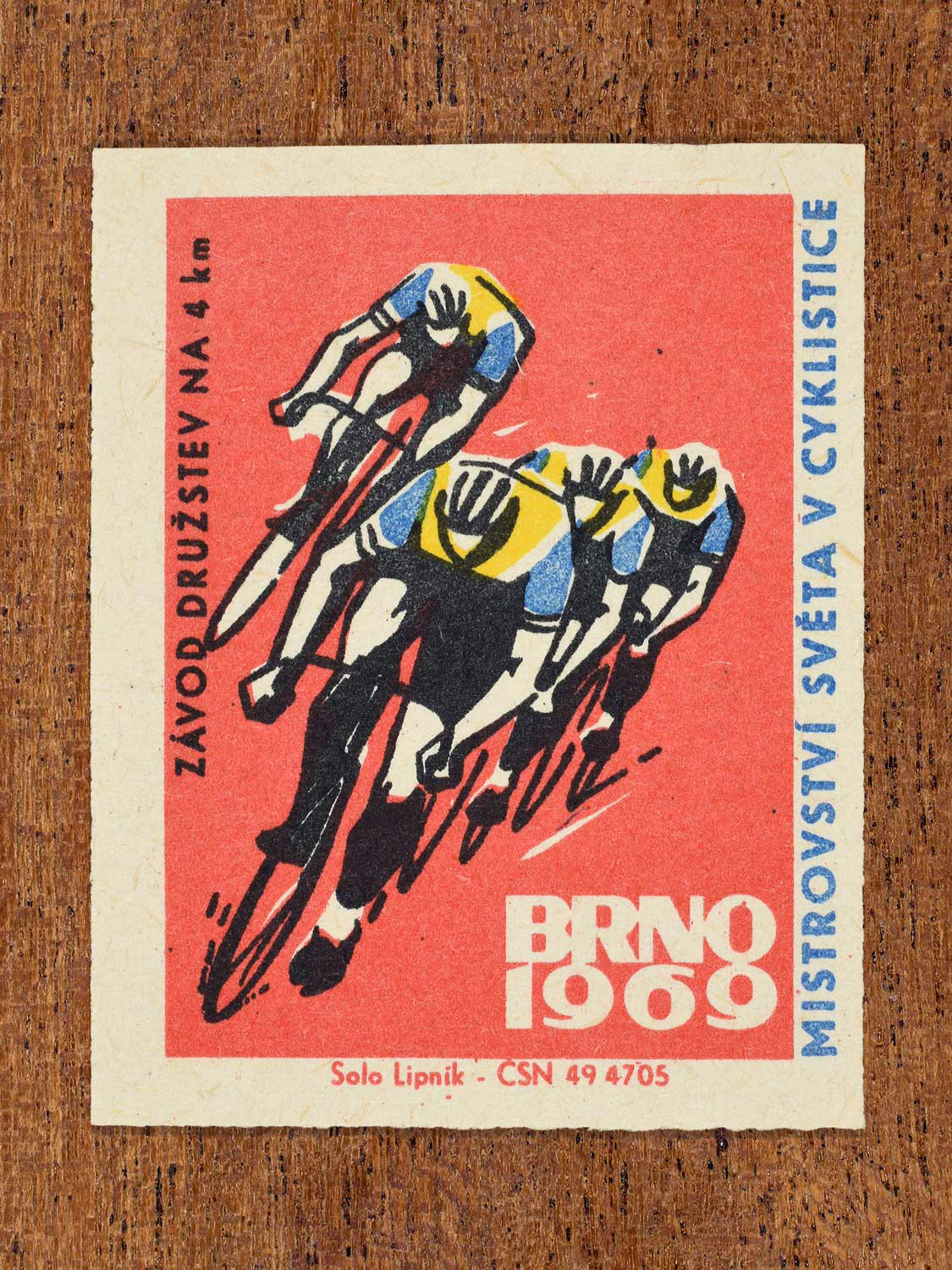 Vintage 1969 Czech matchbox label showing four stylised cyclists racing in a 4 km team event, on a red background. Produced by the Solo Lipník match factory to promote the team pursuit discipline at a cycling championship in Brno, Czechoslovakia.