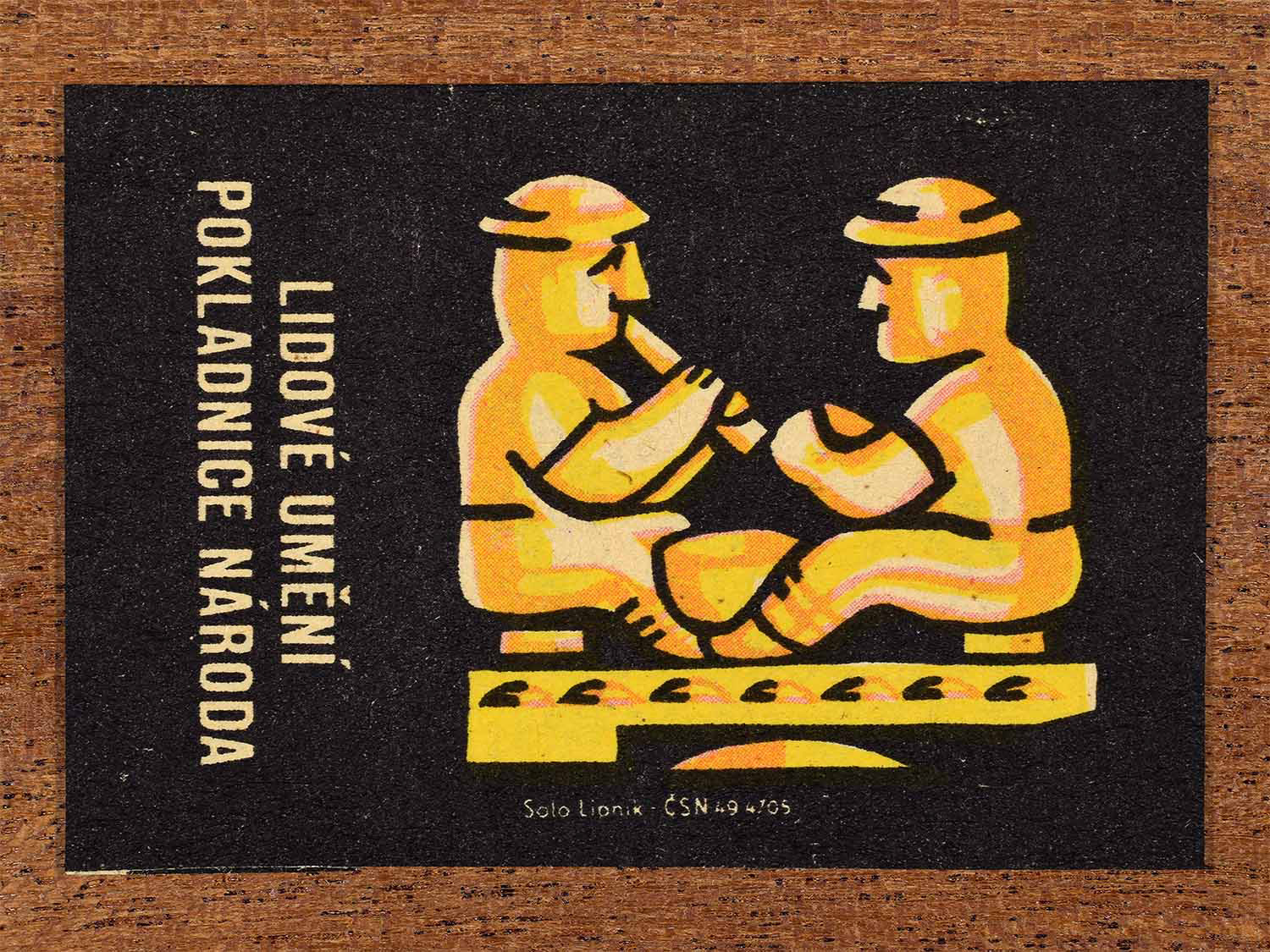 Vintage c. 1962 Czech matchbox label showing a stylised folk ornament in warm yellow and orange tones. Produced by the Solo Lipník match factory to celebrate traditional craft forms.