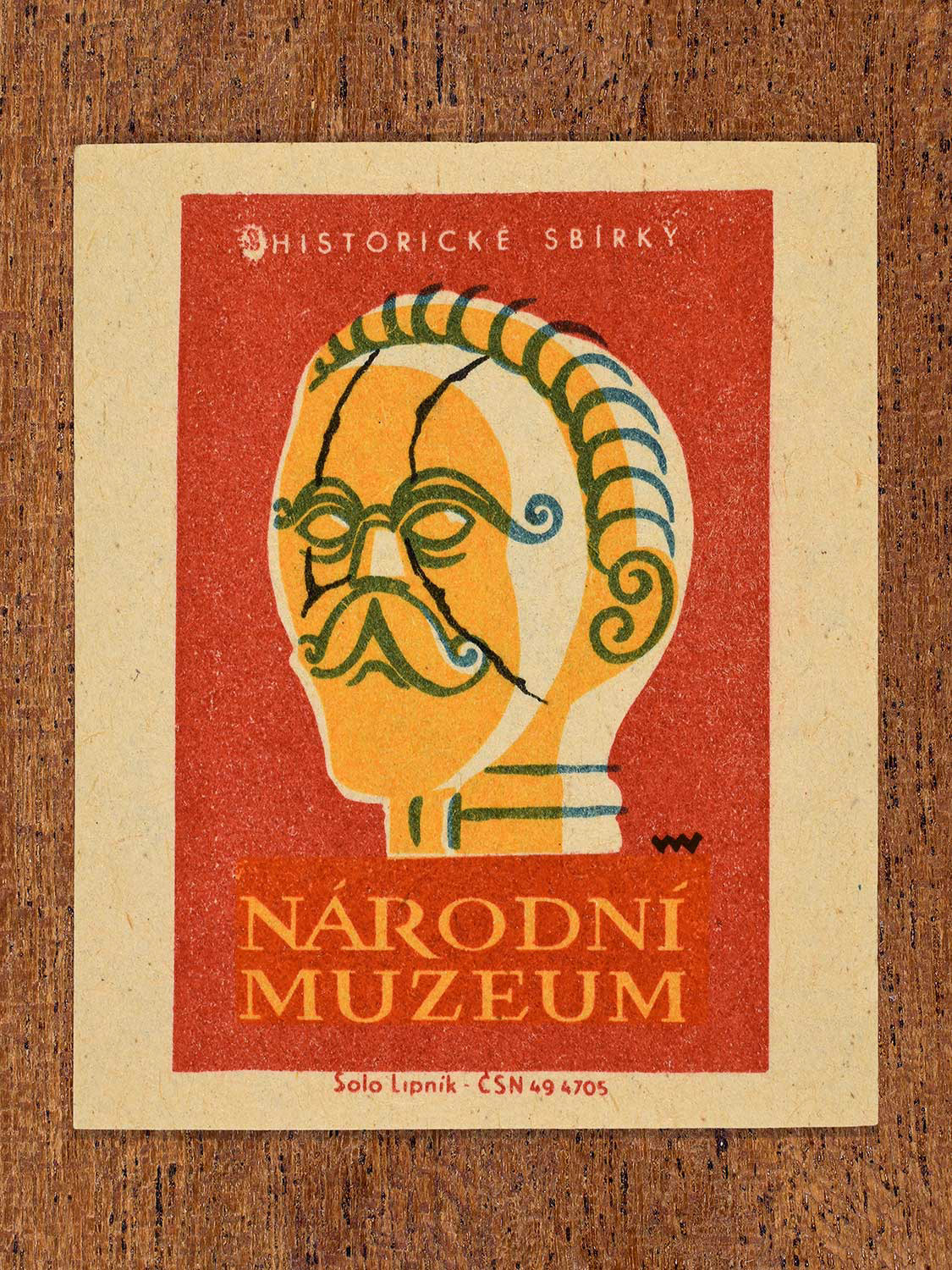 Vintage 1964 Czechoslovakia matchbox label showing a stylised phrenology head in black, yellow, teal and red colours. Produced by the Solo Lipník match factory to promote historical collections at the Národní Muzeum (National Museum) in Czechoslovakia.