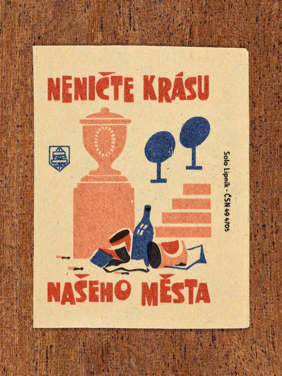 Vintage 1964 Czech matchbox label showing an urban monument surrounded by litter, in blue, red and black colours. Produced by the Solo Lipník match factory to promote respect for the visual beauty of the city.