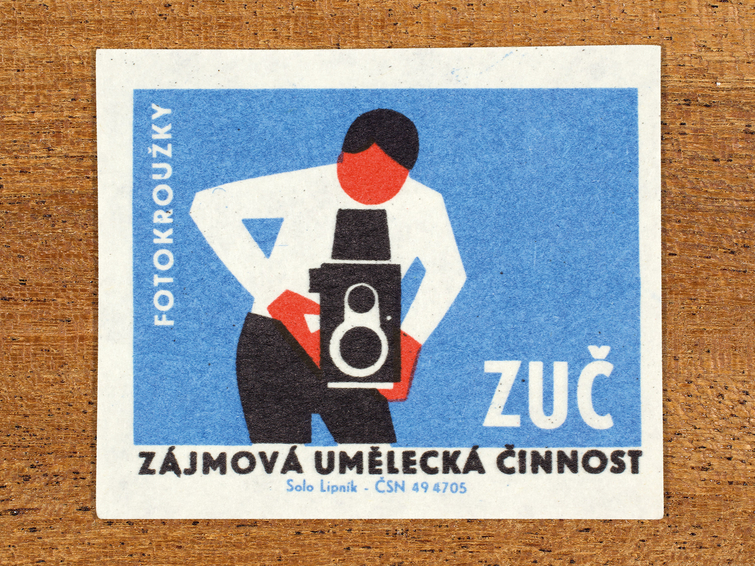 Vintage 1969 Czech matchbox label showing a stylised person holding a camera, in blue, red and black colours. Produced by the Solo Lipník match factory to promote state-organised art groups in Czechoslovakia.
