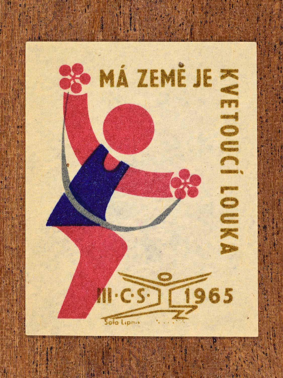 Vintage 1965 Czechoslovak matchbox label showing an athlete holding flowers in blue, red and gold colours. Produced by the Solo Lipník match factory to promote health, vitality, and national pride.