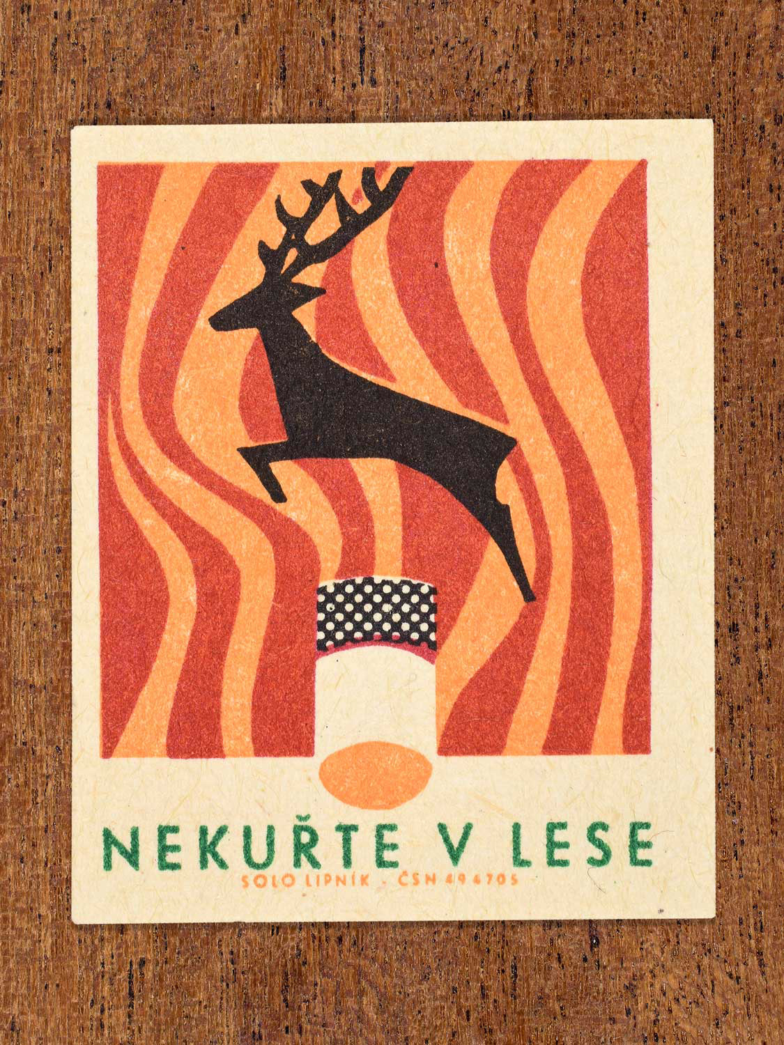 Vintage 1966 Czech matchbox label featuring a cigarette butt with a silhouette of a leaping deer above it with red and orange heatwave lines behind. Produced by Solo Lipník match factory to promote the importance of fire safety precautions.