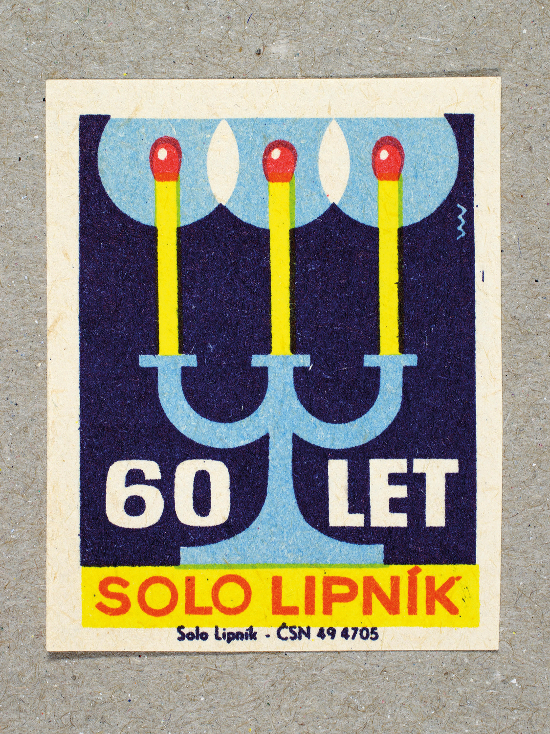 Vintage 1969 Czech matchbox label by Solo Lipník featuring three matches in a candelstick holder in blue and yellow colours. Part of the 'SOLO Lipník Anniversary' series advertising the Czechoslovakian match factory.