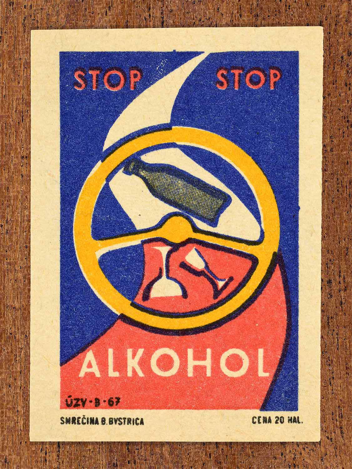 Vintage 1967 Czech matchbox label showing a winding road with a steering wheel, a bottle and drinking glasses in the middle. In red, yellow and blue colours. Produced by the Smrečná match factory, Banská Bystrica, to discourage drink driving.