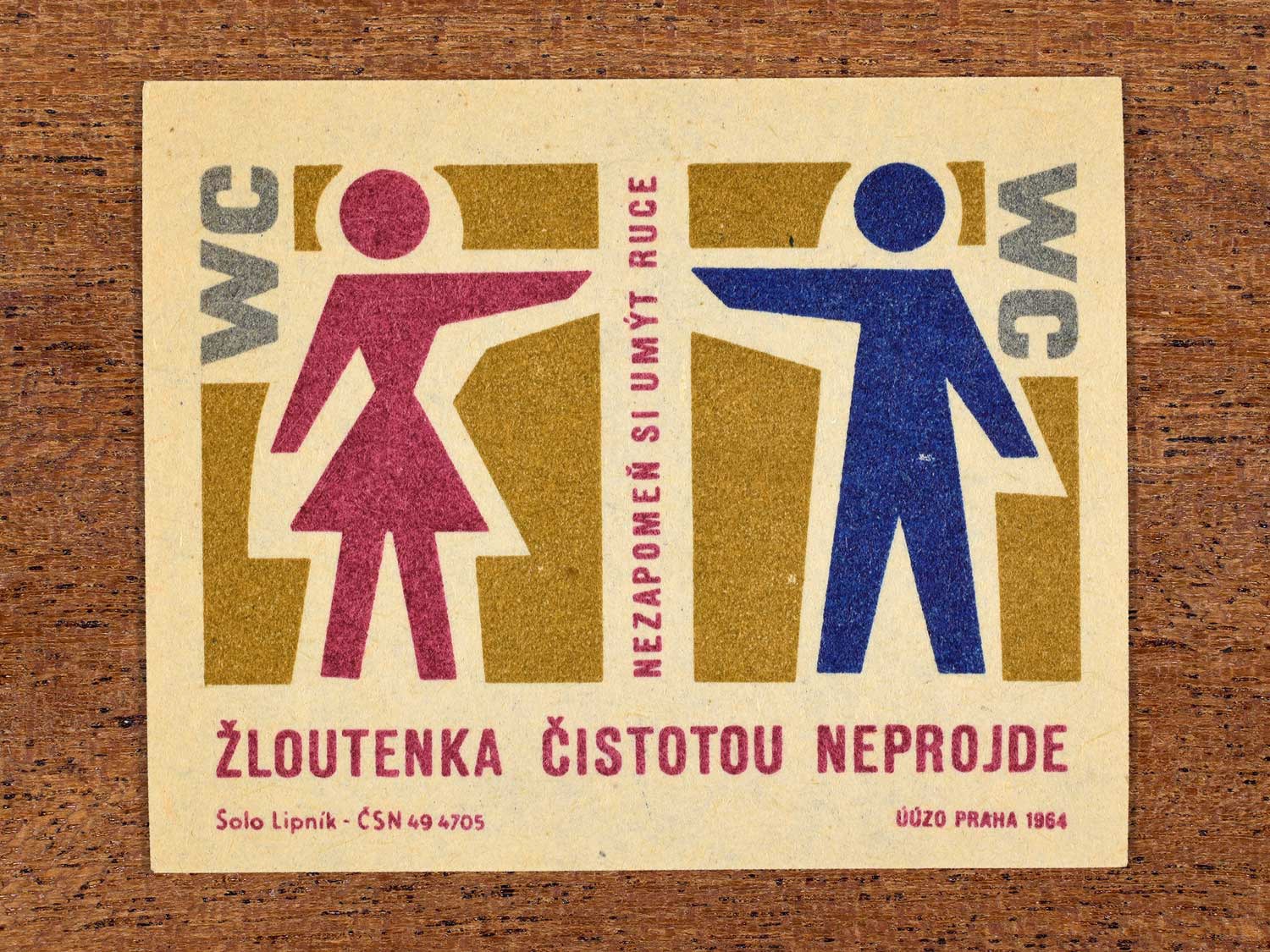 Vintage 1964 Czech matchbox label showing stylised male and female figures leaving a toilet. Produced by the Solo Lipník match factory to promote handwashing in the prevention of infectious jaundice (hepatitis).