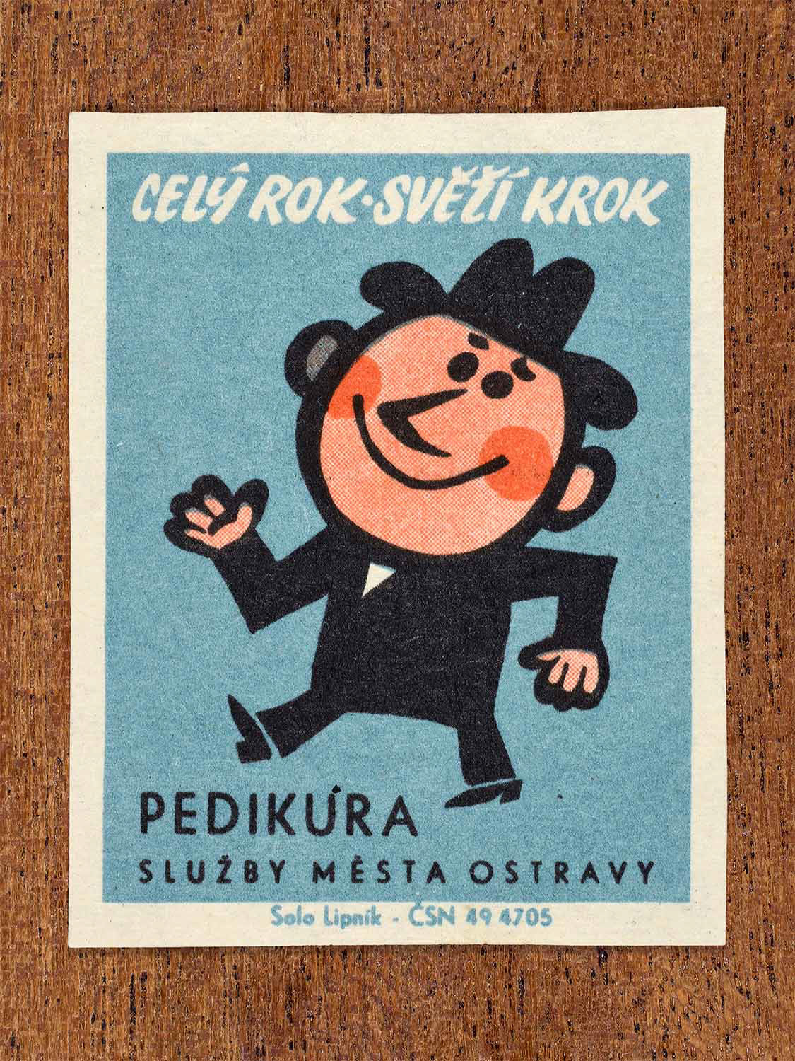 Vintage 1967 Czech matchbox label showing a cheerful cartoon man walking briskly, on a blue background. Produced by the Solo Lipník match factory to promote municipal pedicure hygiene services.