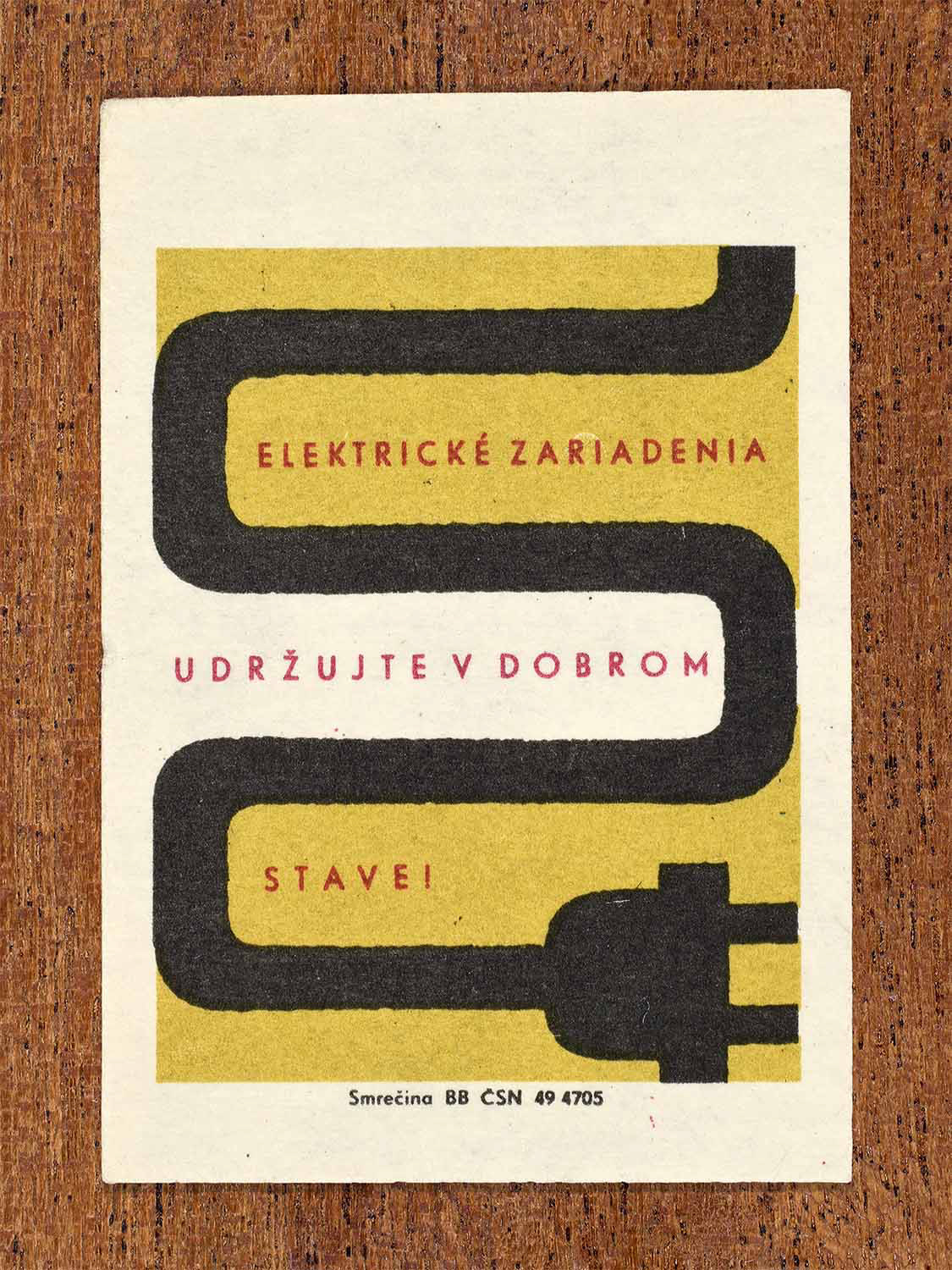 Vintage 1964 Czechoslovak matchbox label showing a stylised electric cable and plug in black, red and yellow colours. Produced by the Smrečina match factory to advise keeping electrical equipment in good condition.