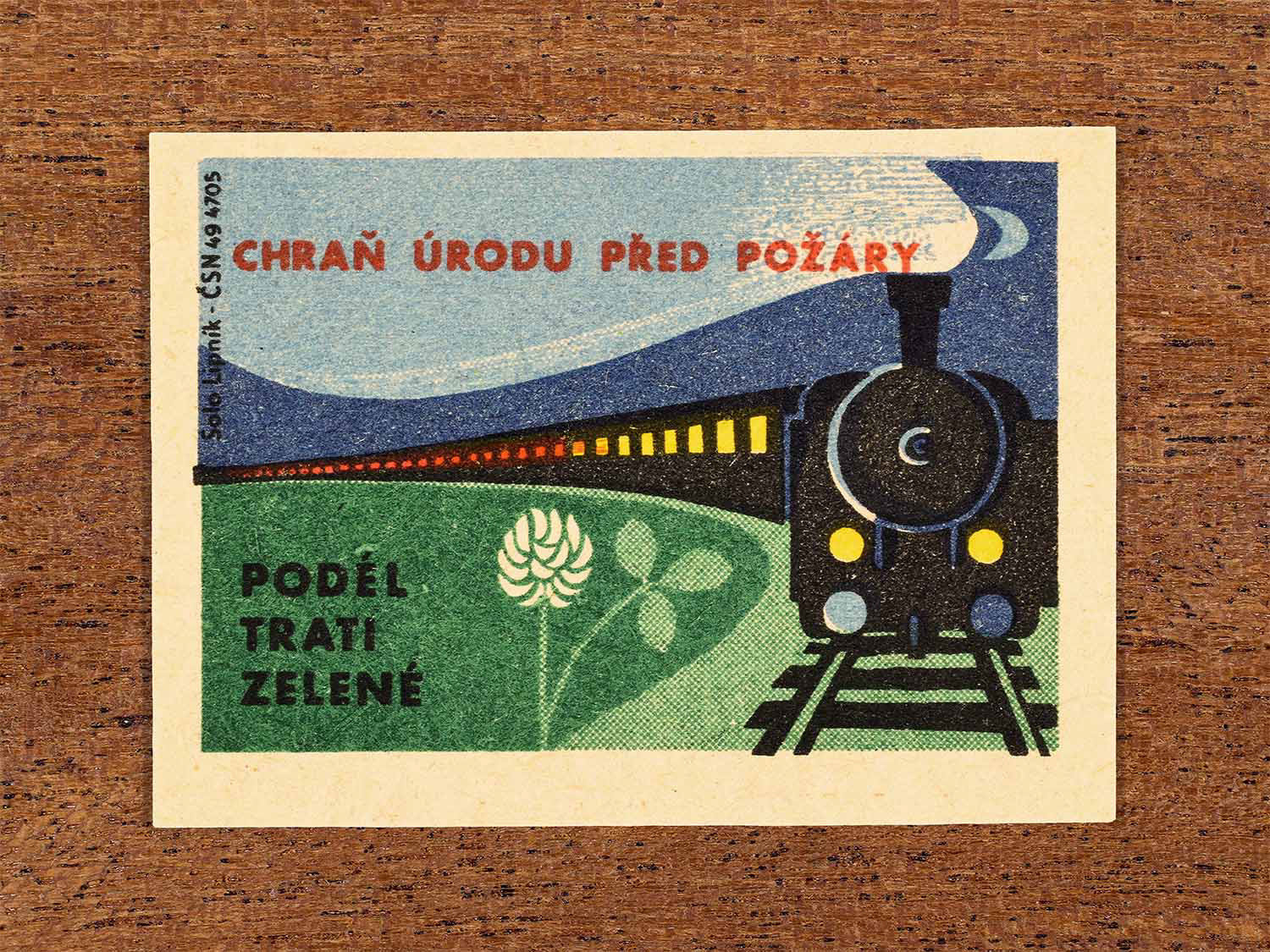Vintage 1964 Czech matchbox label showing a steam locomotive passing farmland. Produced by the Solo Lipník match factory to warn about fire risks to crops along railway lines.