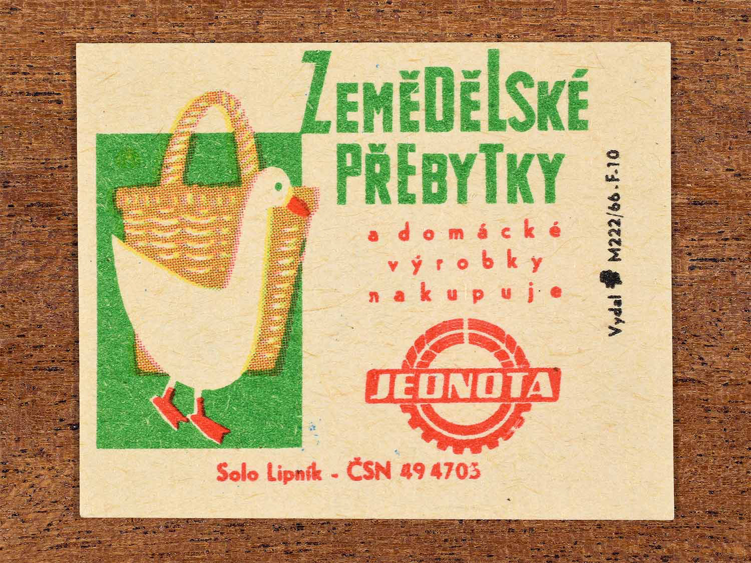 Vintage c. 1966 Czech matchbox label showing a white goose and a basket in bright green and red colours. Produced by the Solo Lipník match factory to promote Jednota purchasing agricultural surpluses and homemade goods.