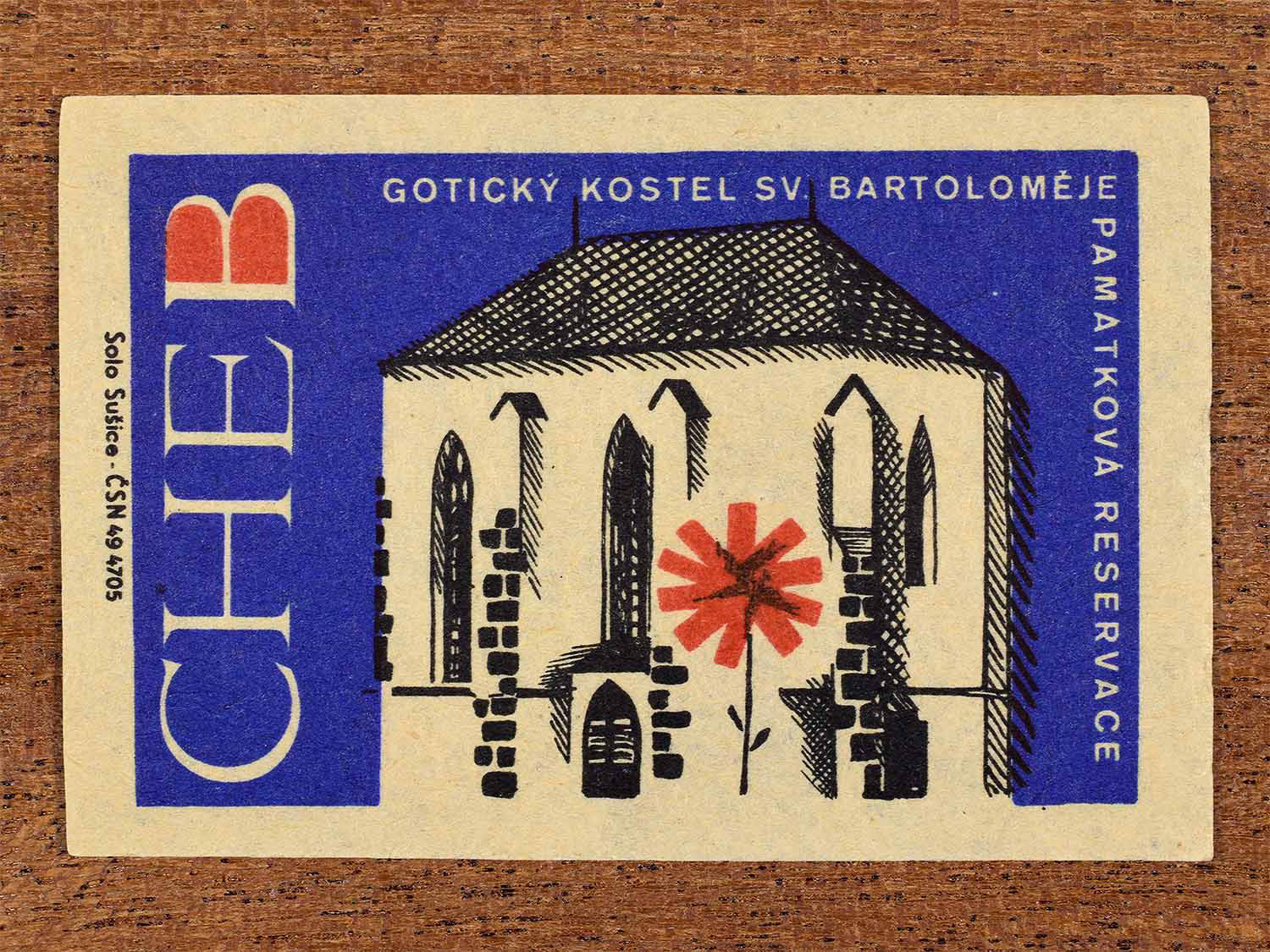 Vintage 1964 Czech matchbox label showing the Gothic Church of St. Bartholomew in Cheb, in blue, red and olive colours. Produced by the Solo Sušice match factory to promote awareness of protected historic monuments.