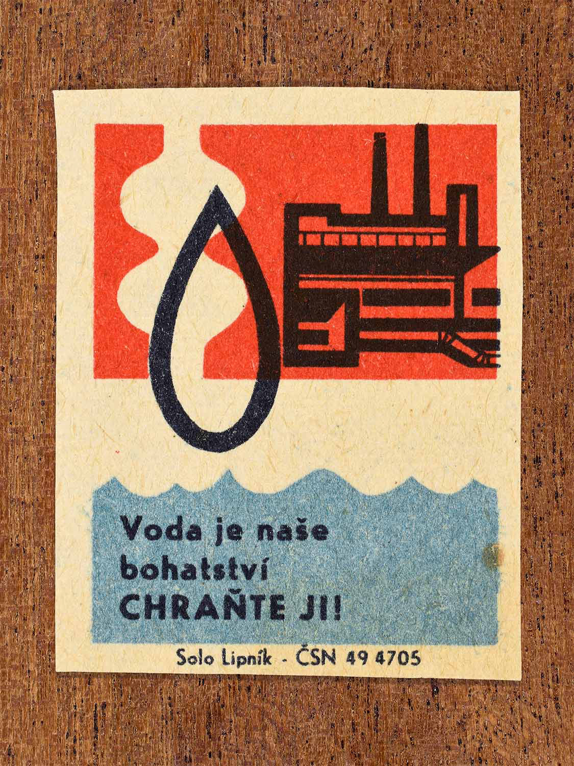 Vintage 1966 Czech matchbox label showing a large water drop beside a factory in red, blue and black colours. Produced by the Solo Lipník match factory to urge protection of water as a national resource.