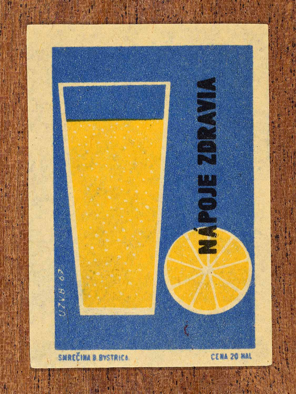Vintage 1967 Czech matchbox label showing a glass of juice and a slice of lemon in blue and yellow colours. Produced by the Smrečná match factory, Banská Bystrica, to promote healthy beverages.