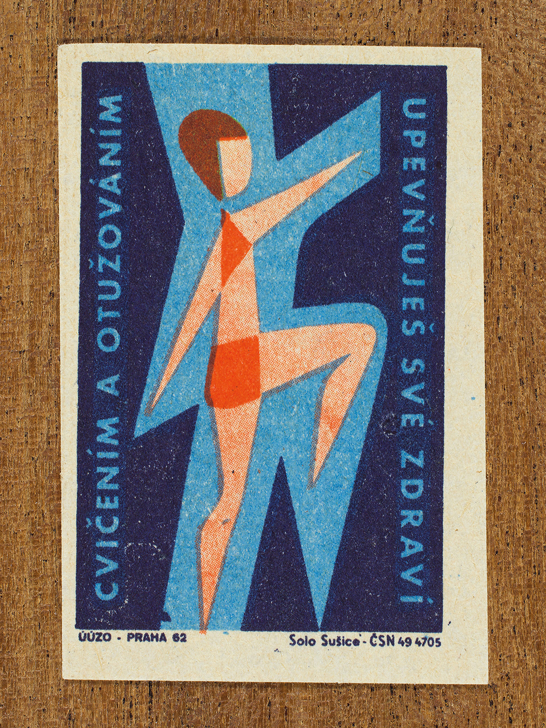 Vintage 1962 Czech matchbox label by Solo Sušice featuring a stylized female figure wearing a swimming costume, and outlined in blue. Part of the 'Protect Health' series promoting cold-water hardening to build resistance and health.