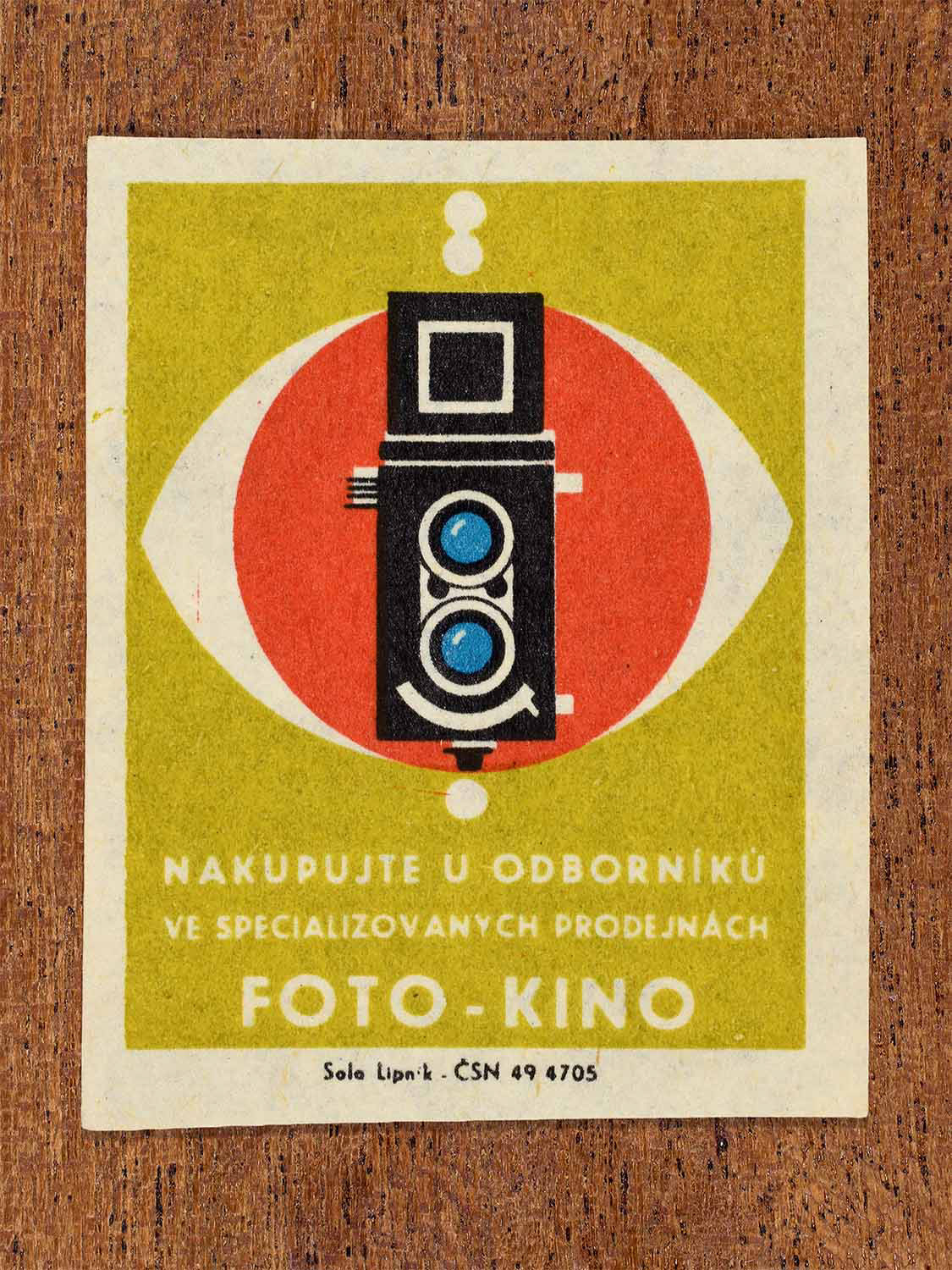 Vintage c. 1967 Czech matchbox label showing a twin-lens camera in red, yellow, blue and black colours. Produced by the Solo Lipník match factory to promote shopping for photographic and cinema equipment in specialised retail stores.