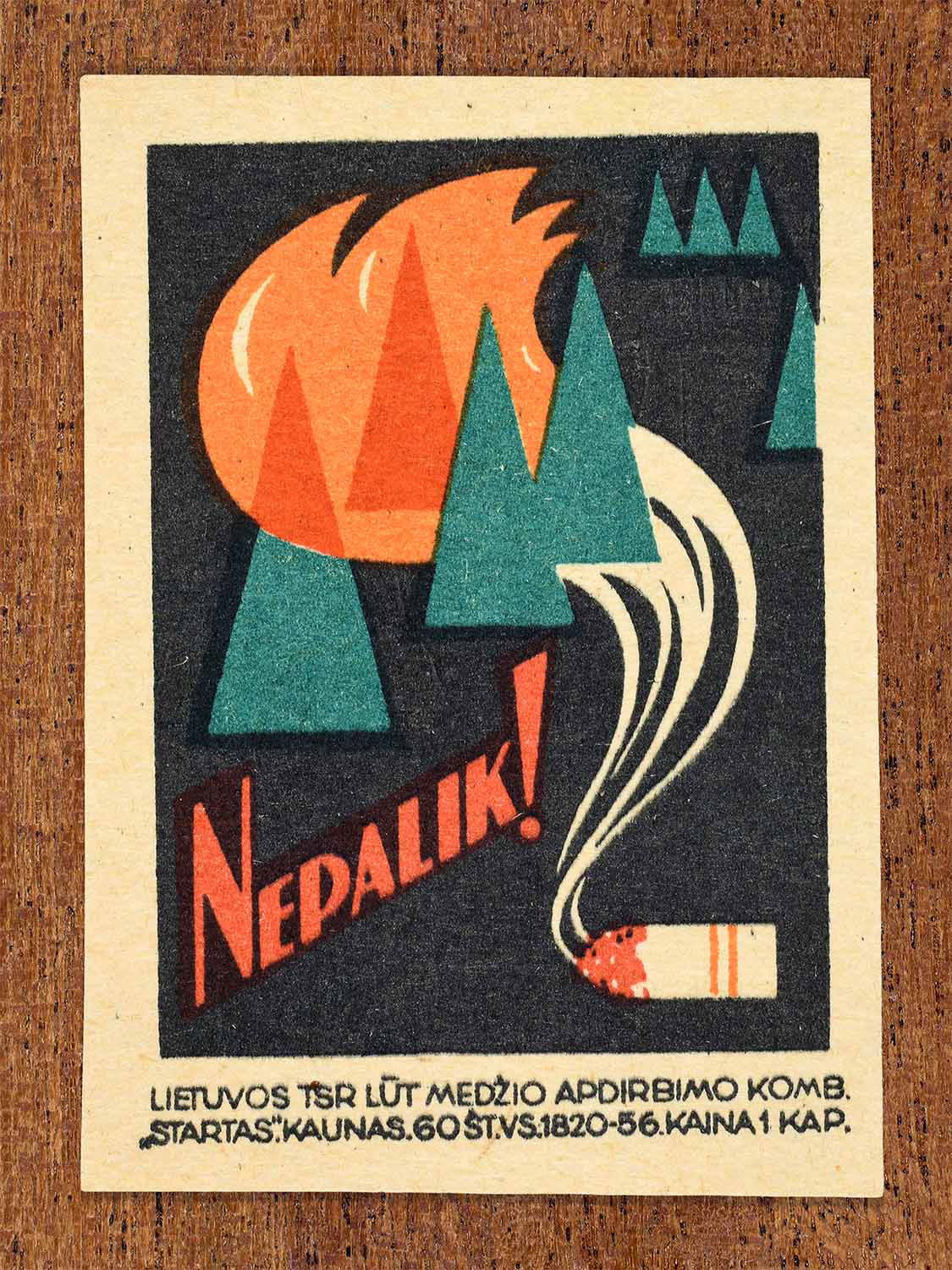 Vintage 1964 Lithuanian matchbox label showing a burning forest ignited by a discarded cigarette in bold orange and green tones. Produced by the Startas match factory to promote fire safety and preventing forest fires.
