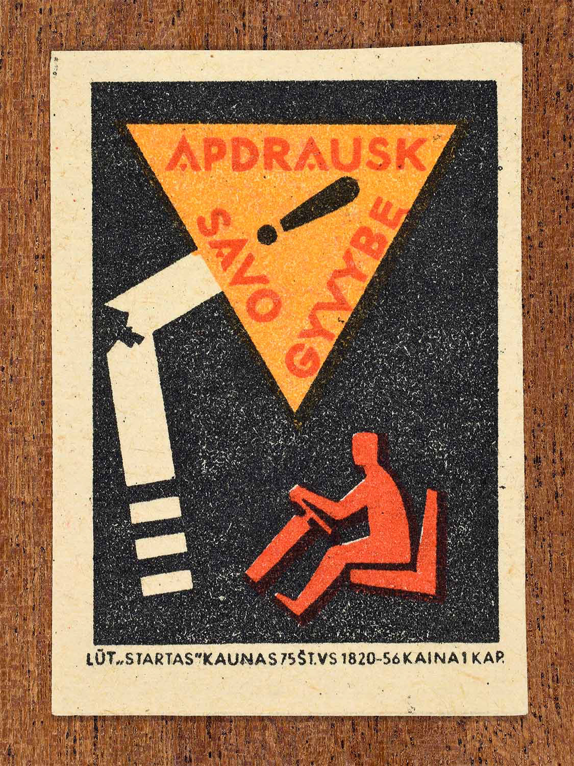 Vintage 1963 Lithuanian matchbox label showing a stylised driving figure and a damaged road sign, in orange and black colours. Produced by the Startas Kaunas match factory to promote life insurance.