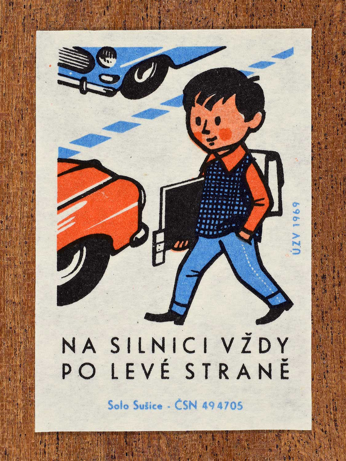 Vintage 1969 Czech matchbox label showing a young schoolboy walking properly on the left side of a road facing traffic. Produced by the Solo Sušice match factory to promote safe walking regulations facing oncoming vehicles.