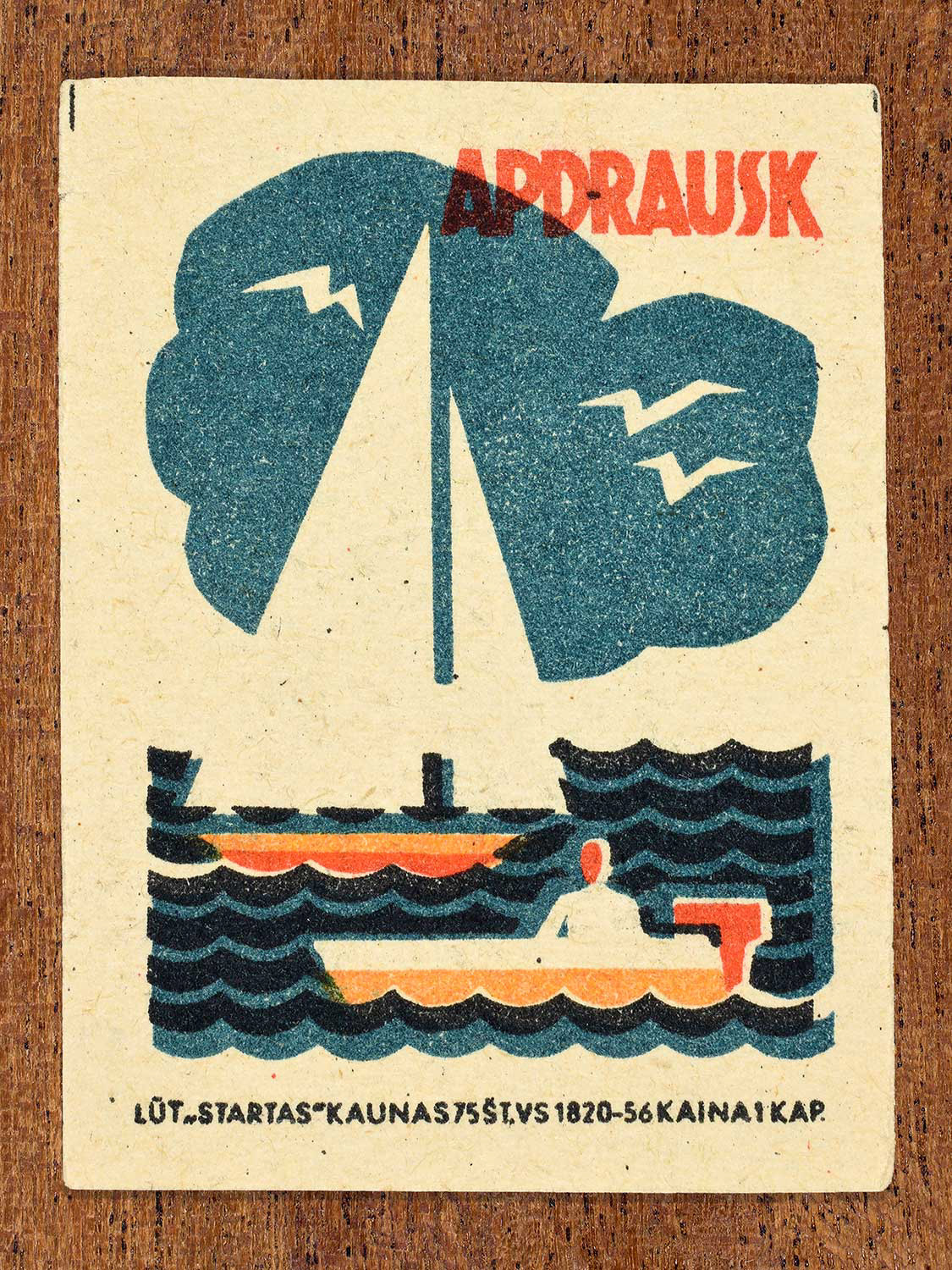 Vintage 1963 Lithuanian matchbox label showing a boat on the sea in blue, orange, and black colours. Produced by the Startas Kaunas match factory to promote insurance for property.