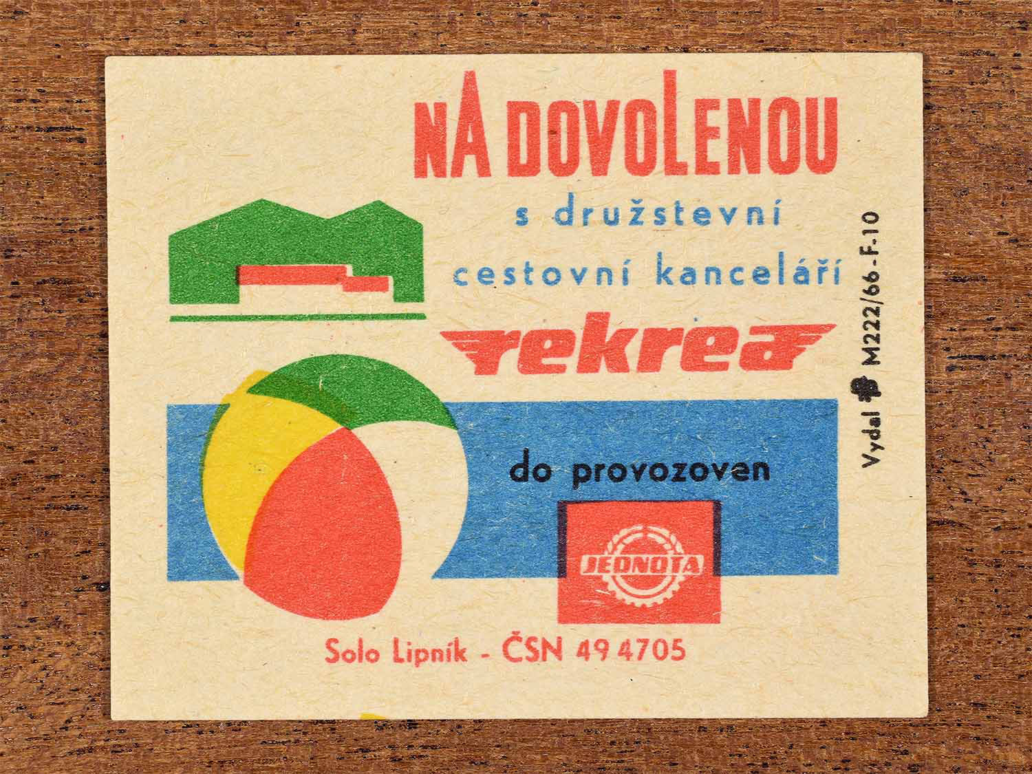 Vintage c. 1966 Czech matchbox label showing a beach ball and stylised holiday building in bold geometric colours. Produced by the Solo Lipník match factory to promote holidays organised by a cooperative travel agency through Jednota facilities.